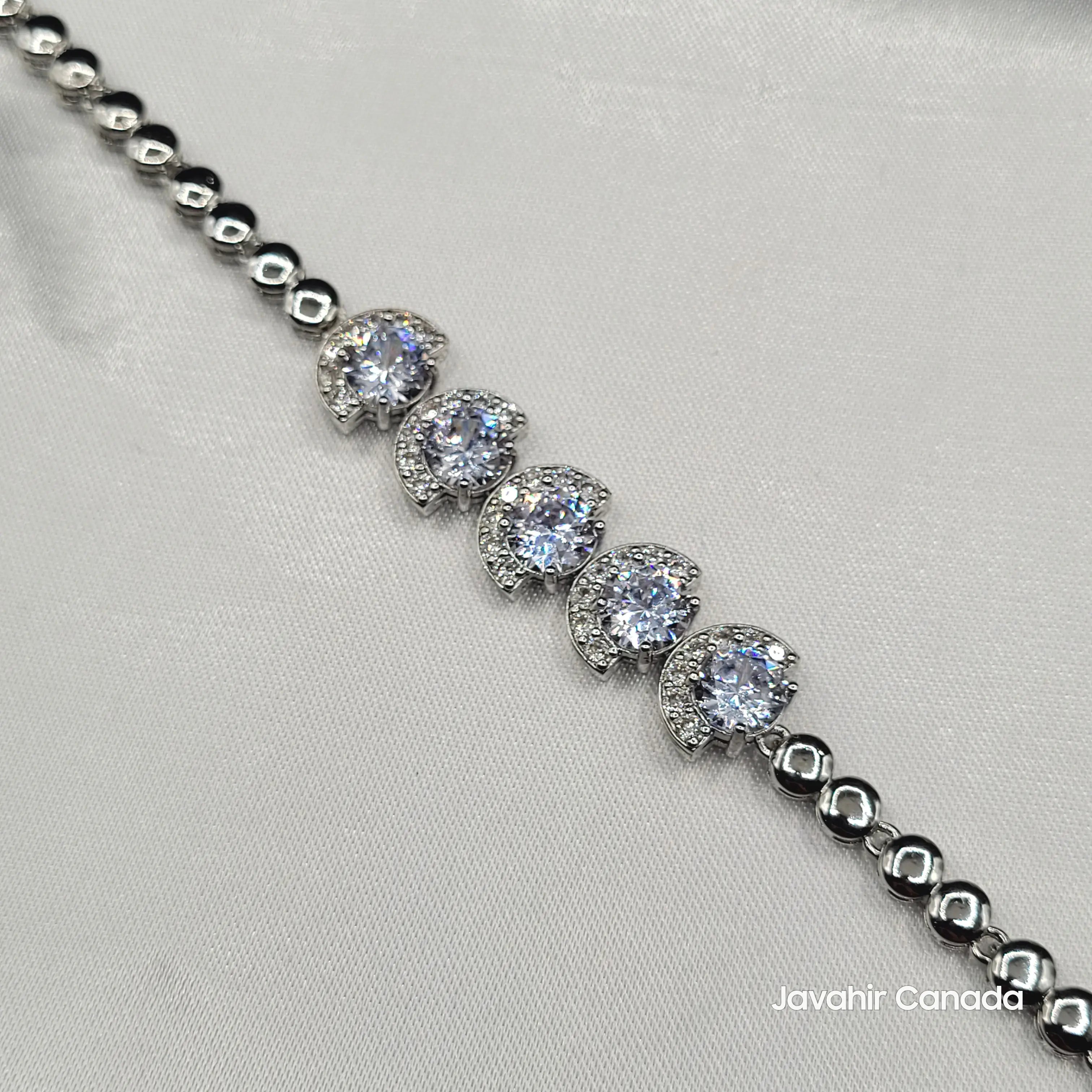 Close-up of JV4014 bracelet featuring round American diamonds with crescent pavé halos on silver chain