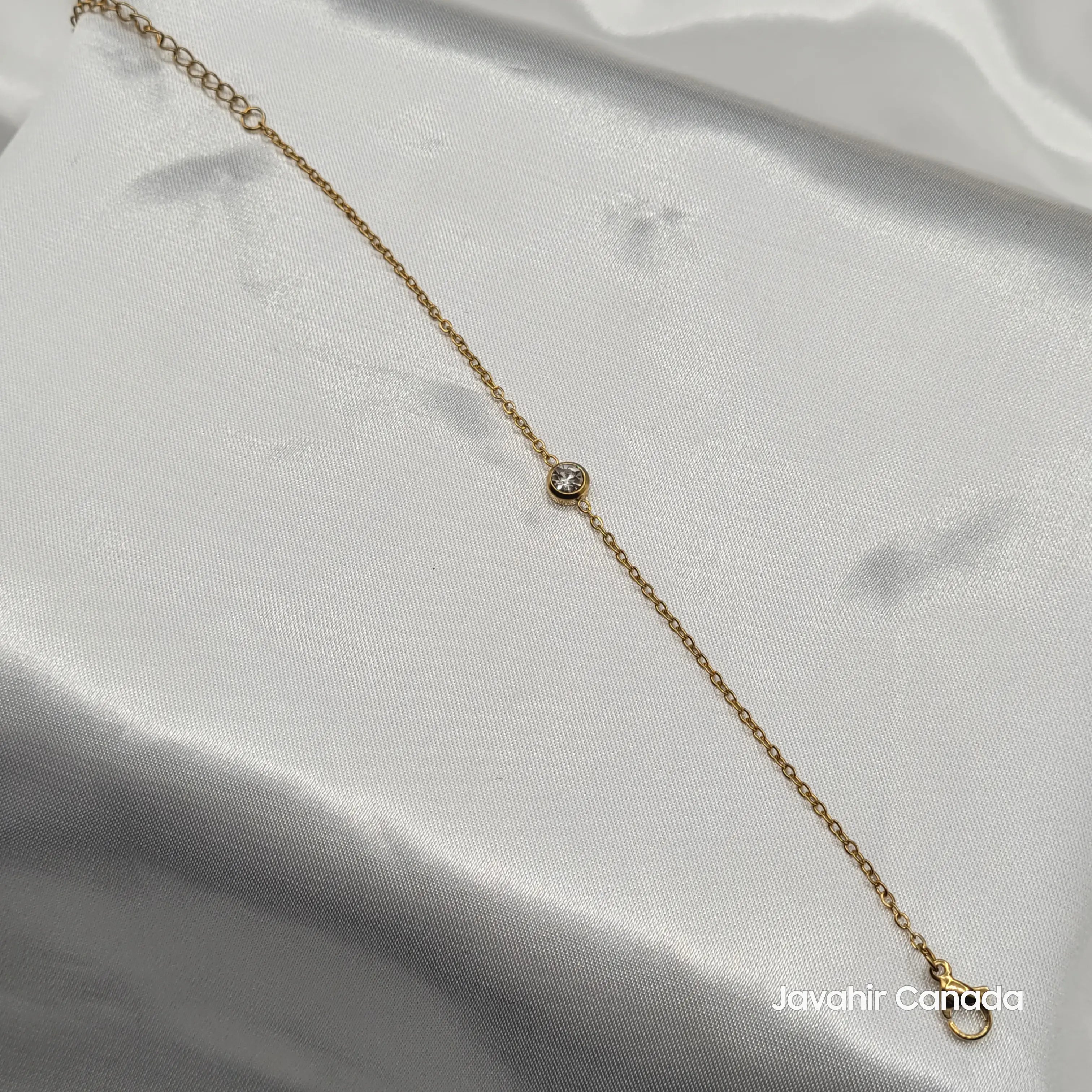 JV4021 minimalist gold-plated bracelet with bezel-set CZ diamond displayed on white fabric