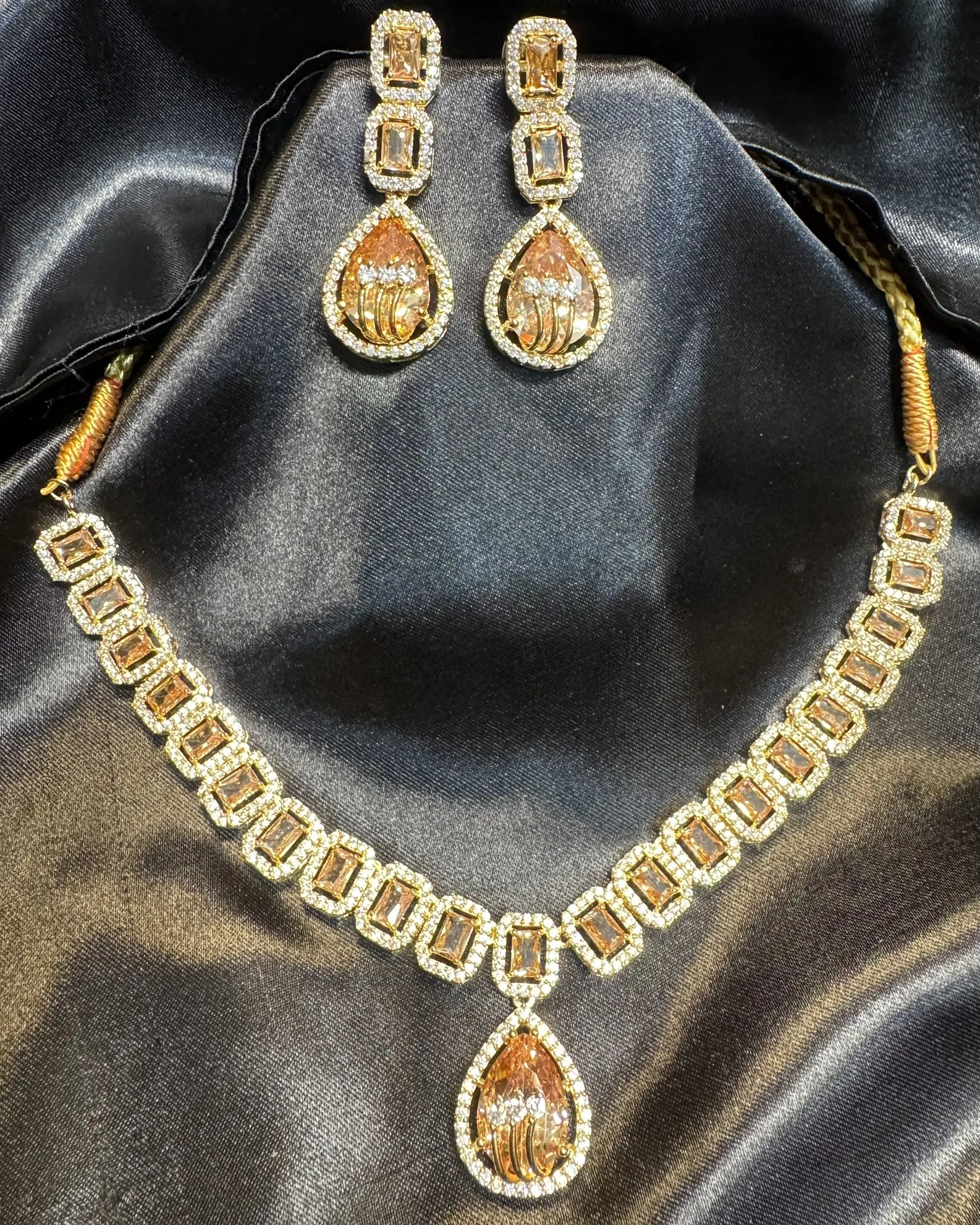American diamond and gold plated necklace set with champagne gemstones on a black satin background