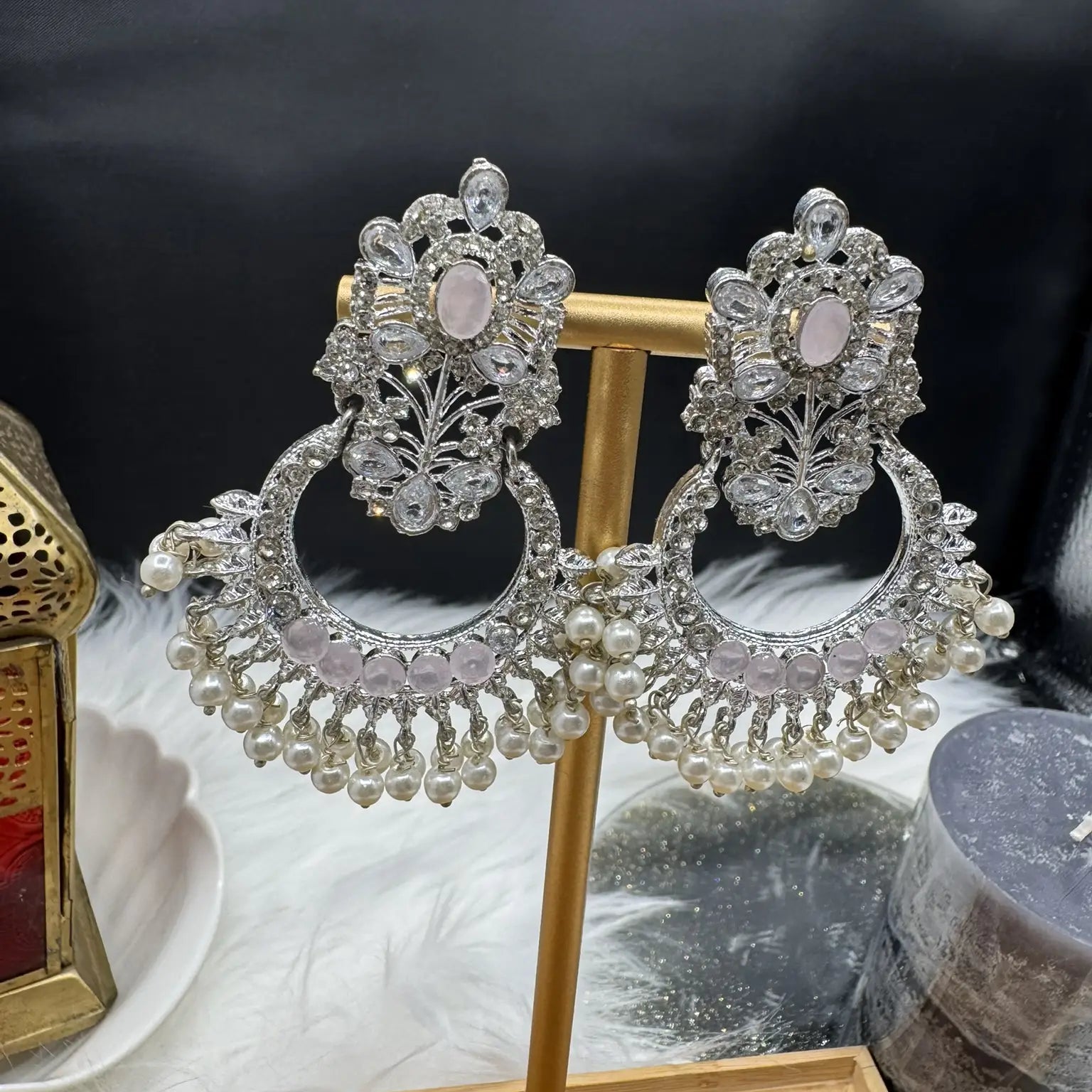 Pakistani style traditional earrings on a stand with a dark background