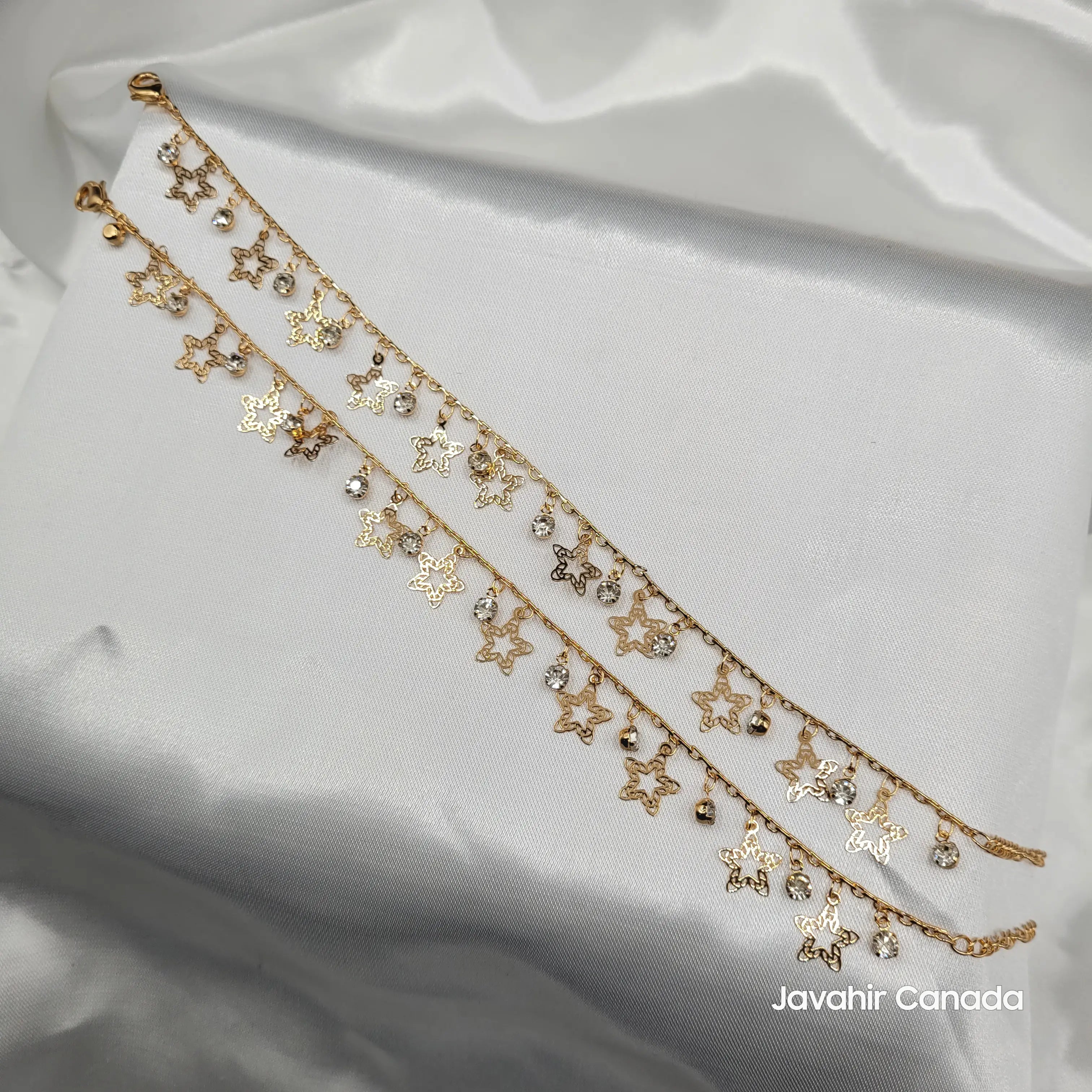 JV5011 gold plated anklet pair with star outline charms and clear crystal drops on satin background