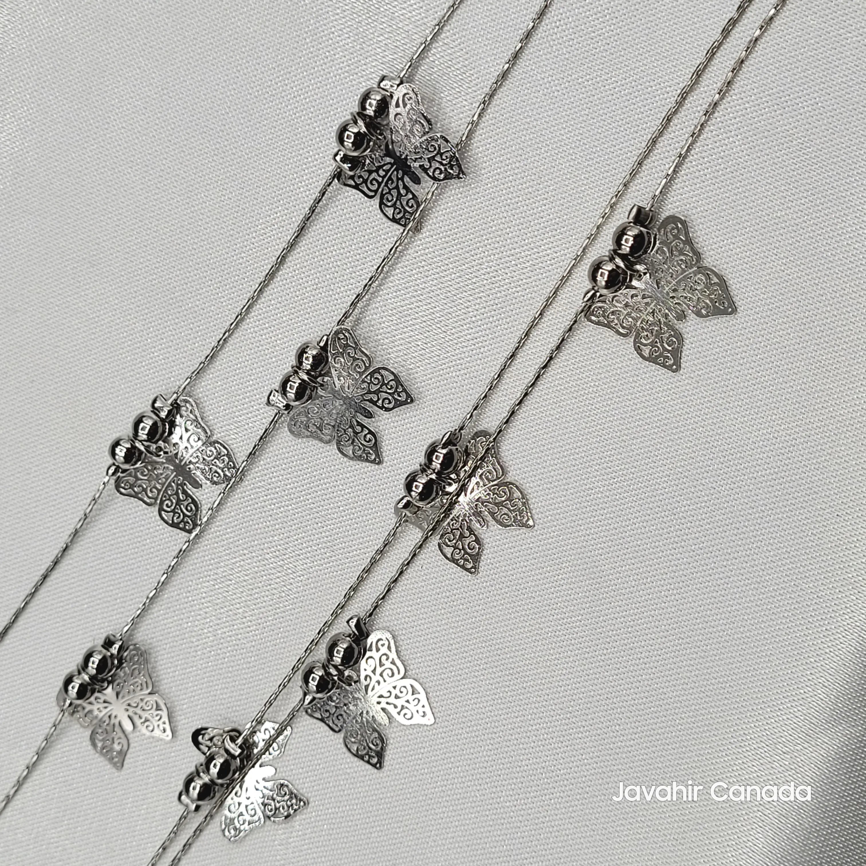 Close-up of JV5013 anklets featuring silver butterfly cutout charms and metallic beads on fine chains
