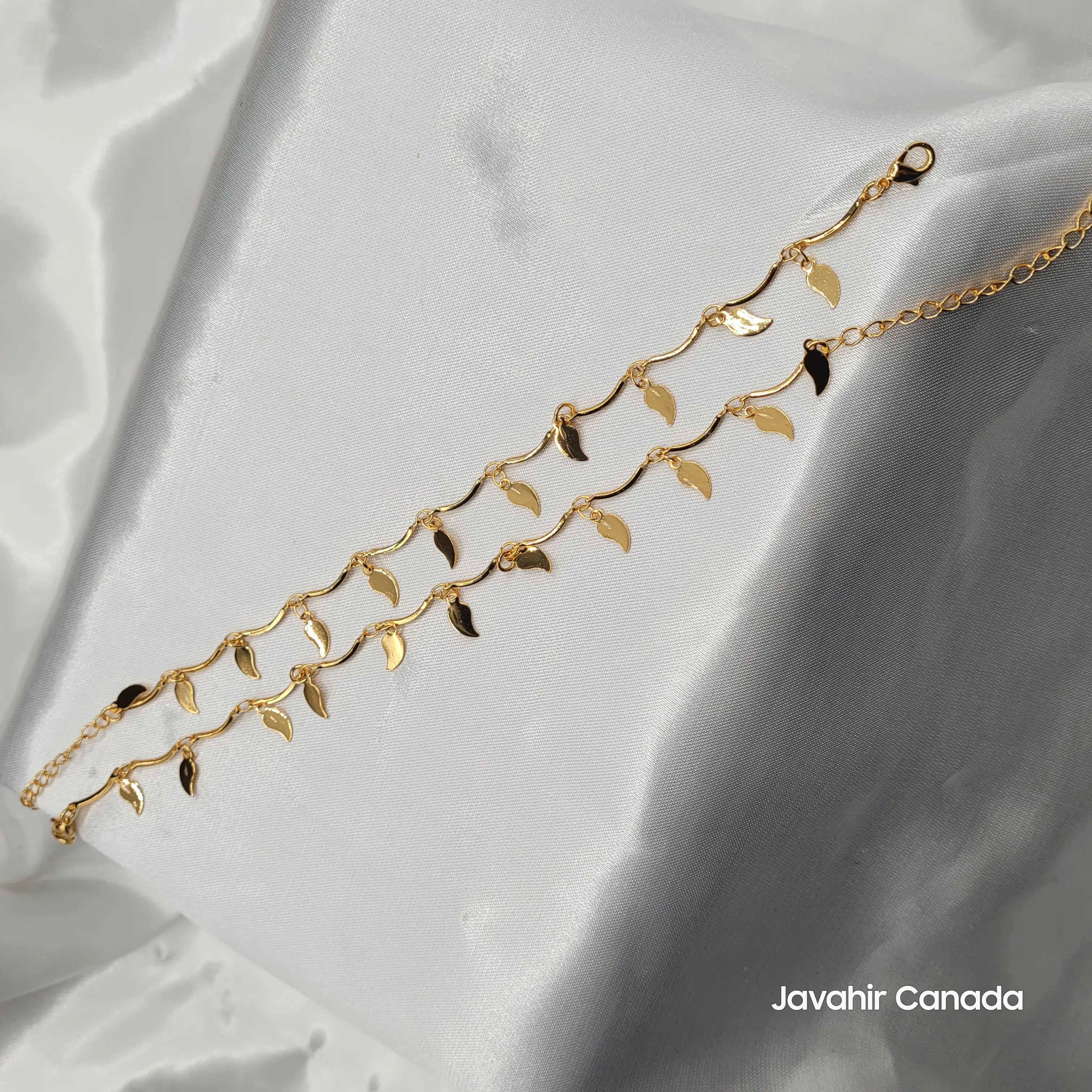 JV5016 gold-plated anklet pair with small dangling leaf charms displayed on satin
