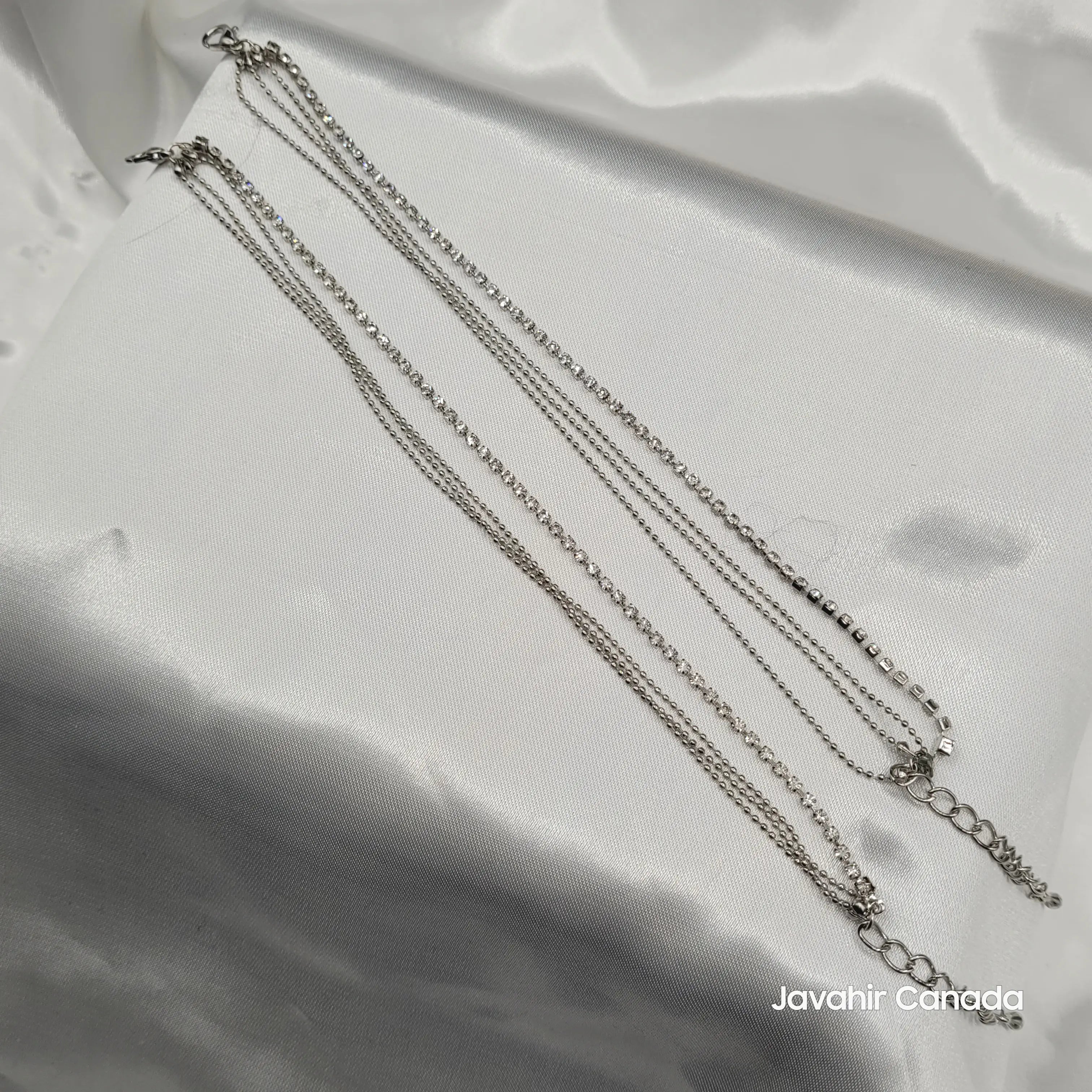 JV5019 silver anklet pair with American diamonds and beaded chains displayed on white satin