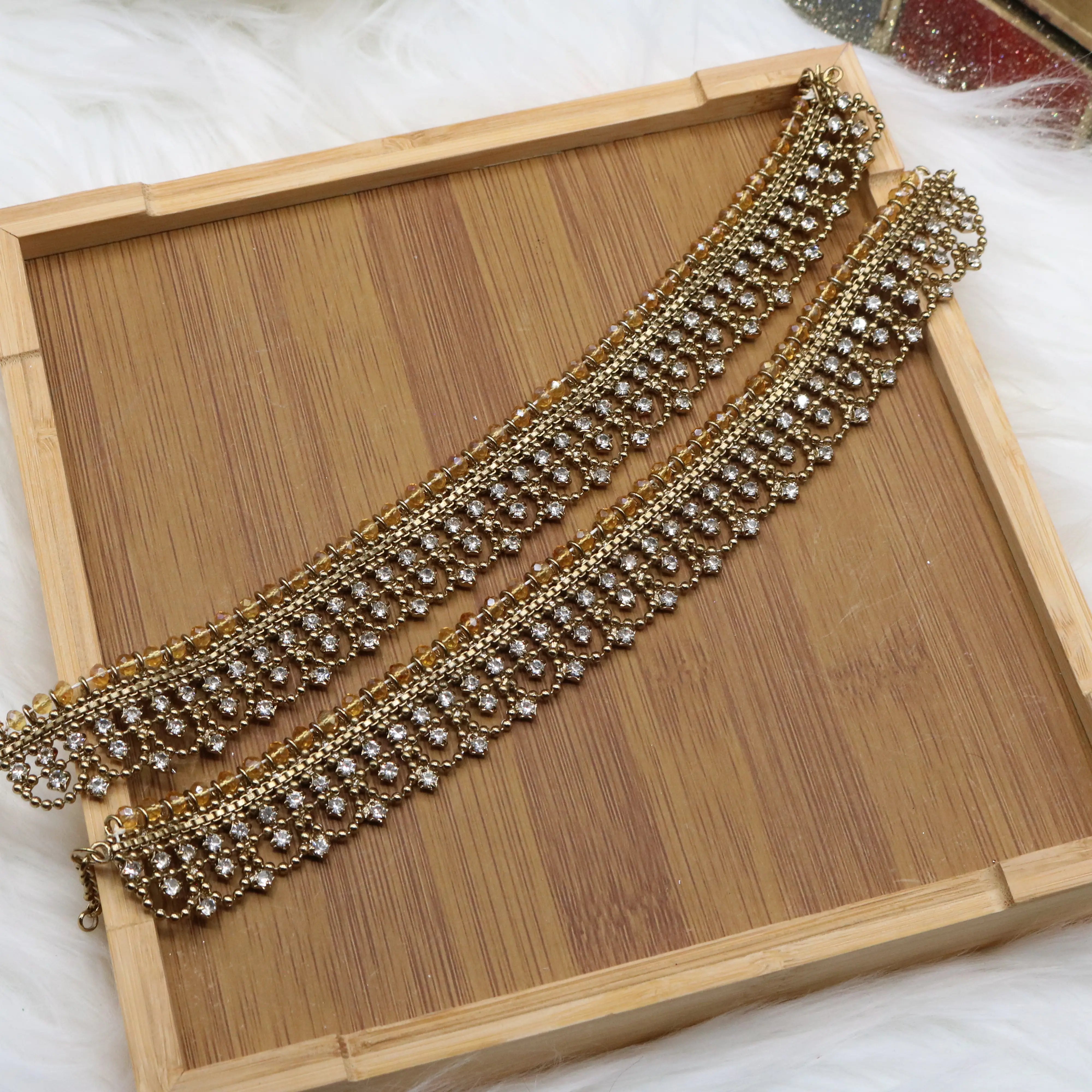 Gold plated heavy anklet pair with crystal detailing displayed on a wooden tray – JV5024