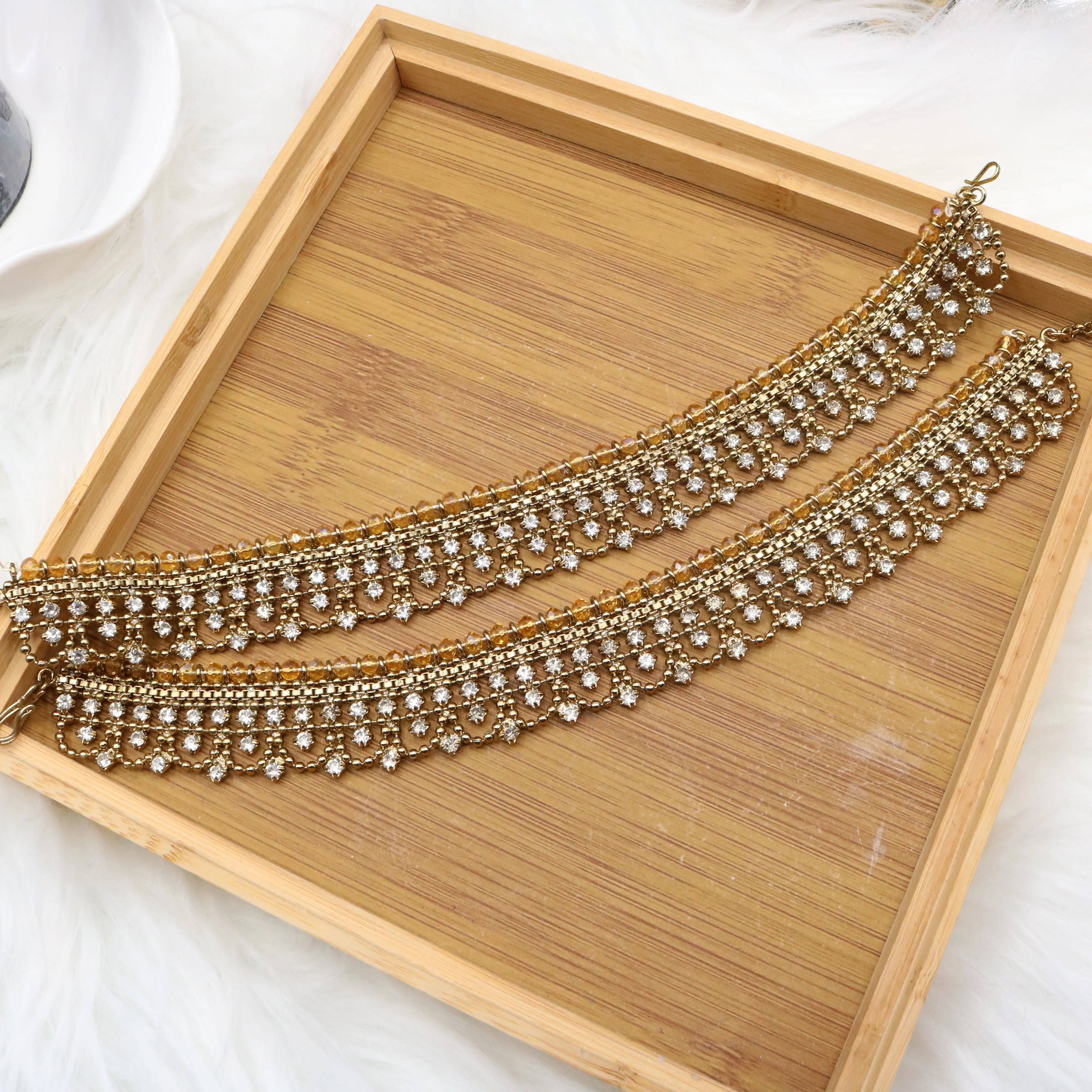 Diagonal flat lay of gold anklet set with sparkling white crystals – JV5024