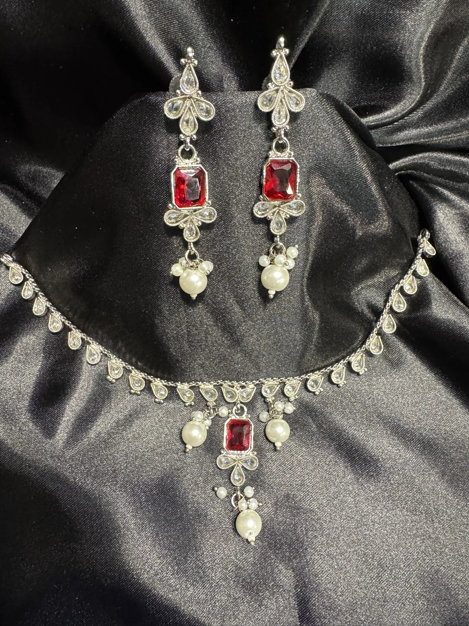 Jewelry set with necklace and earrings on a black satin background