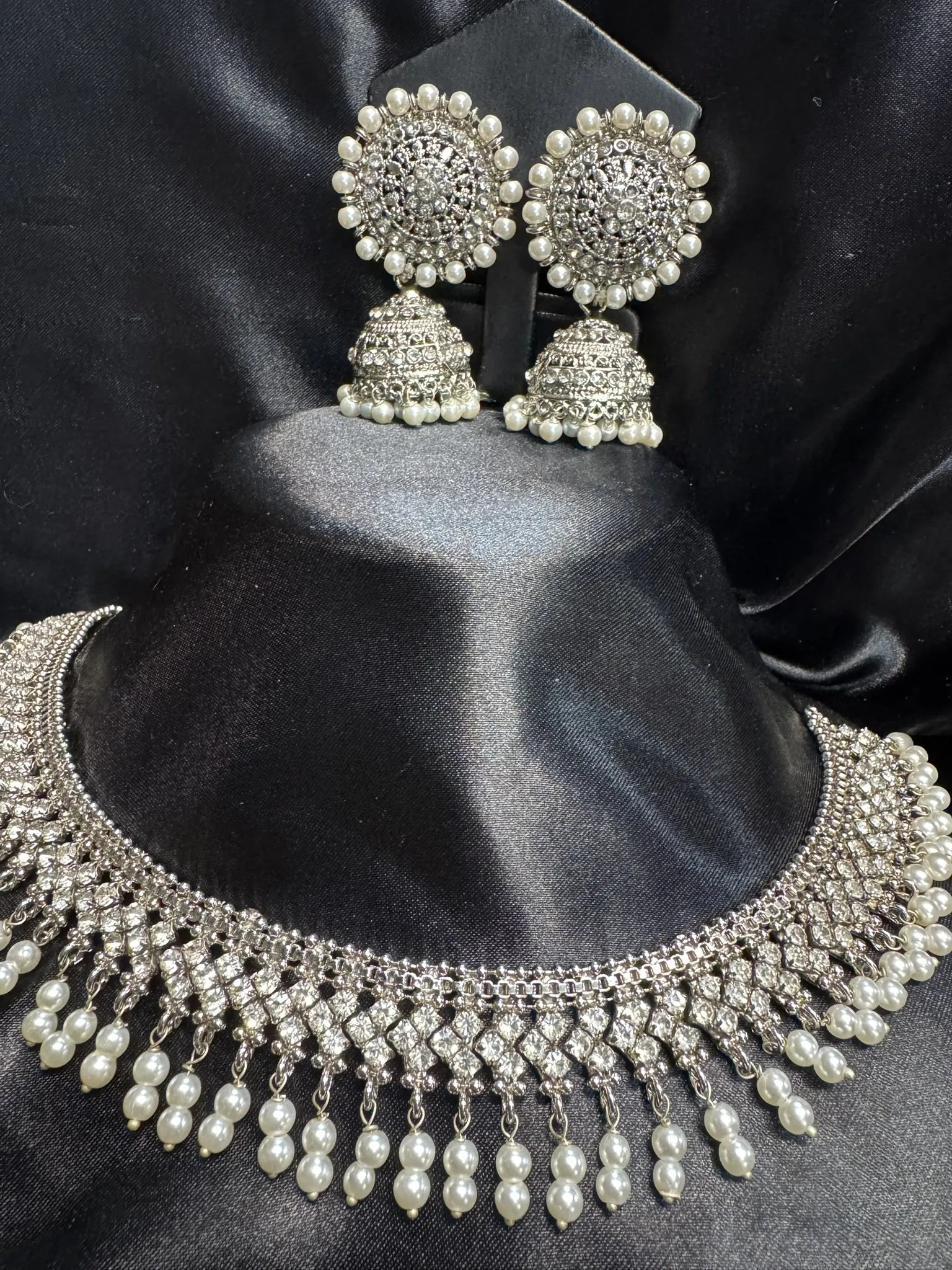 Side view of JV59 pearl drop necklace and intricate CZ earrings with dome-shaped jhumkas