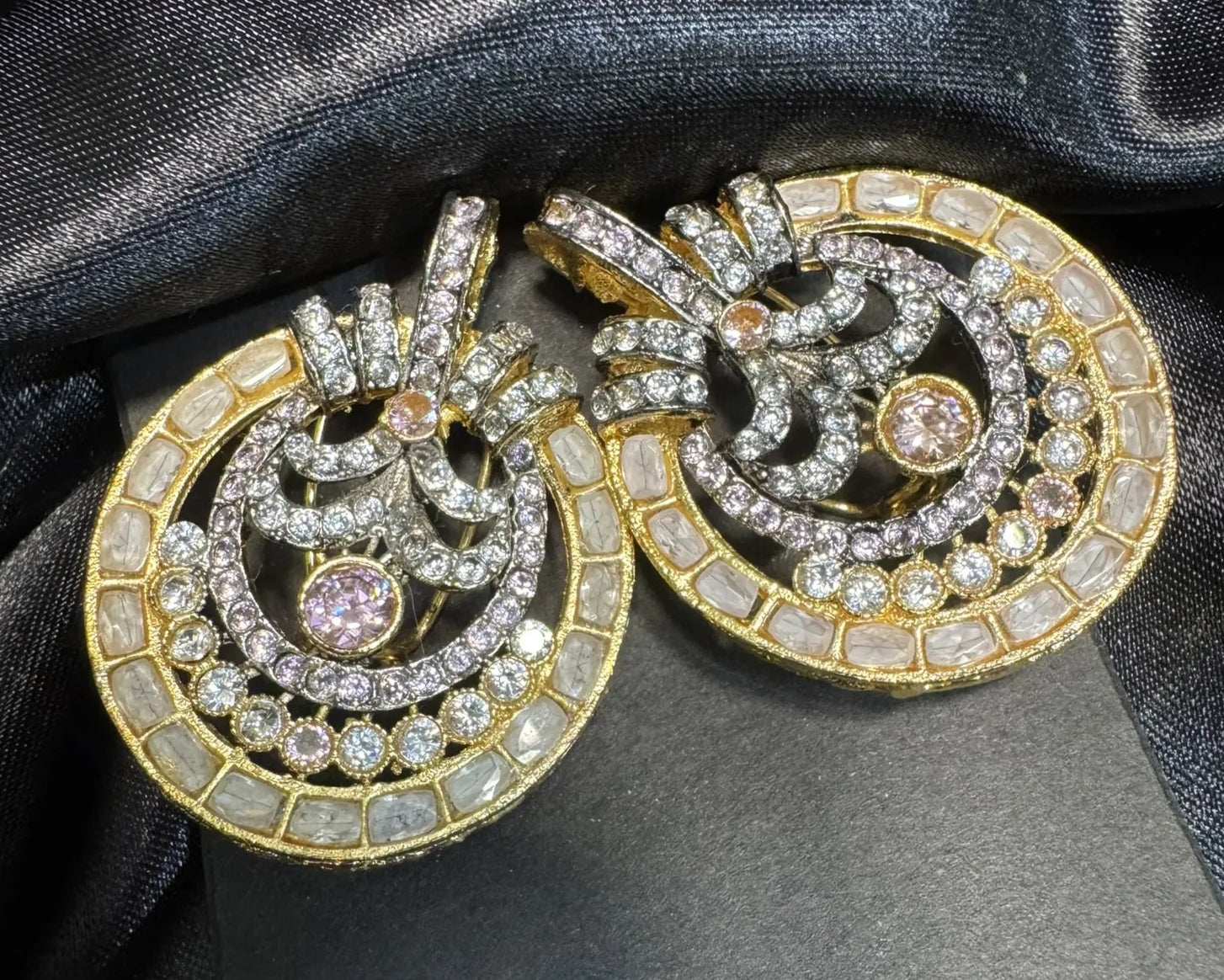 Champagne and pink American diamond earrings on a black satin background