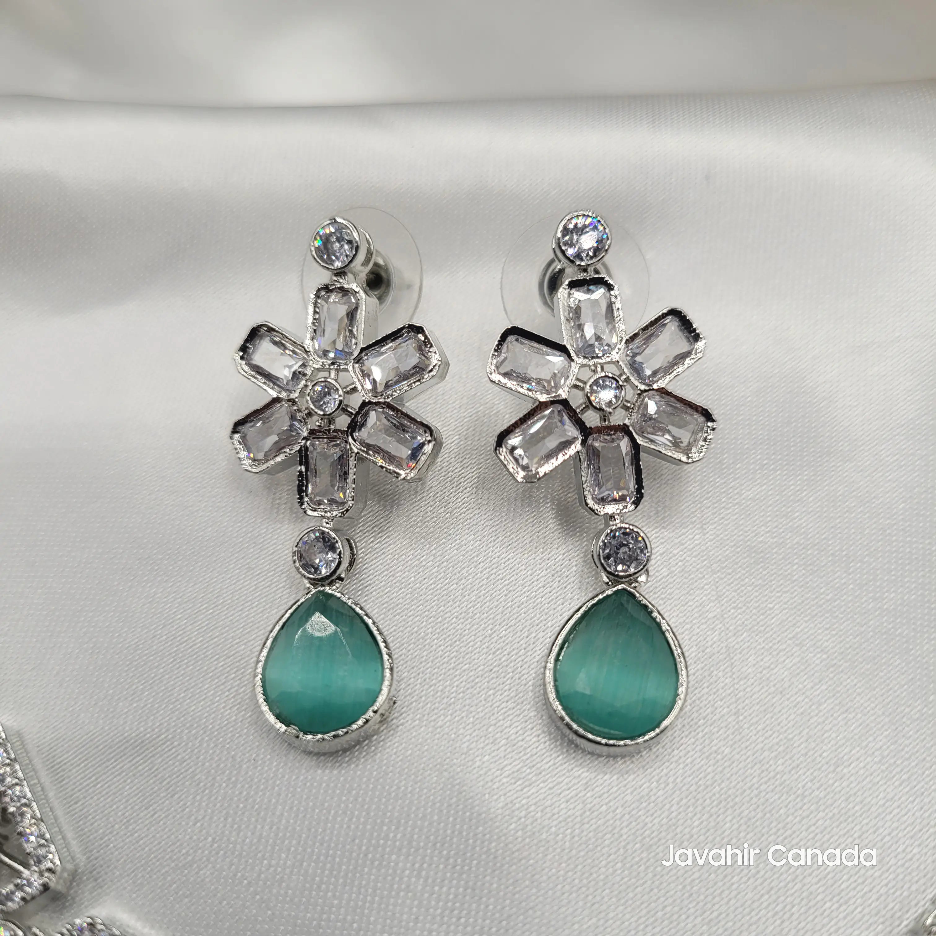 Close-up of mint green teardrop earrings with sparkling CZ flower tops