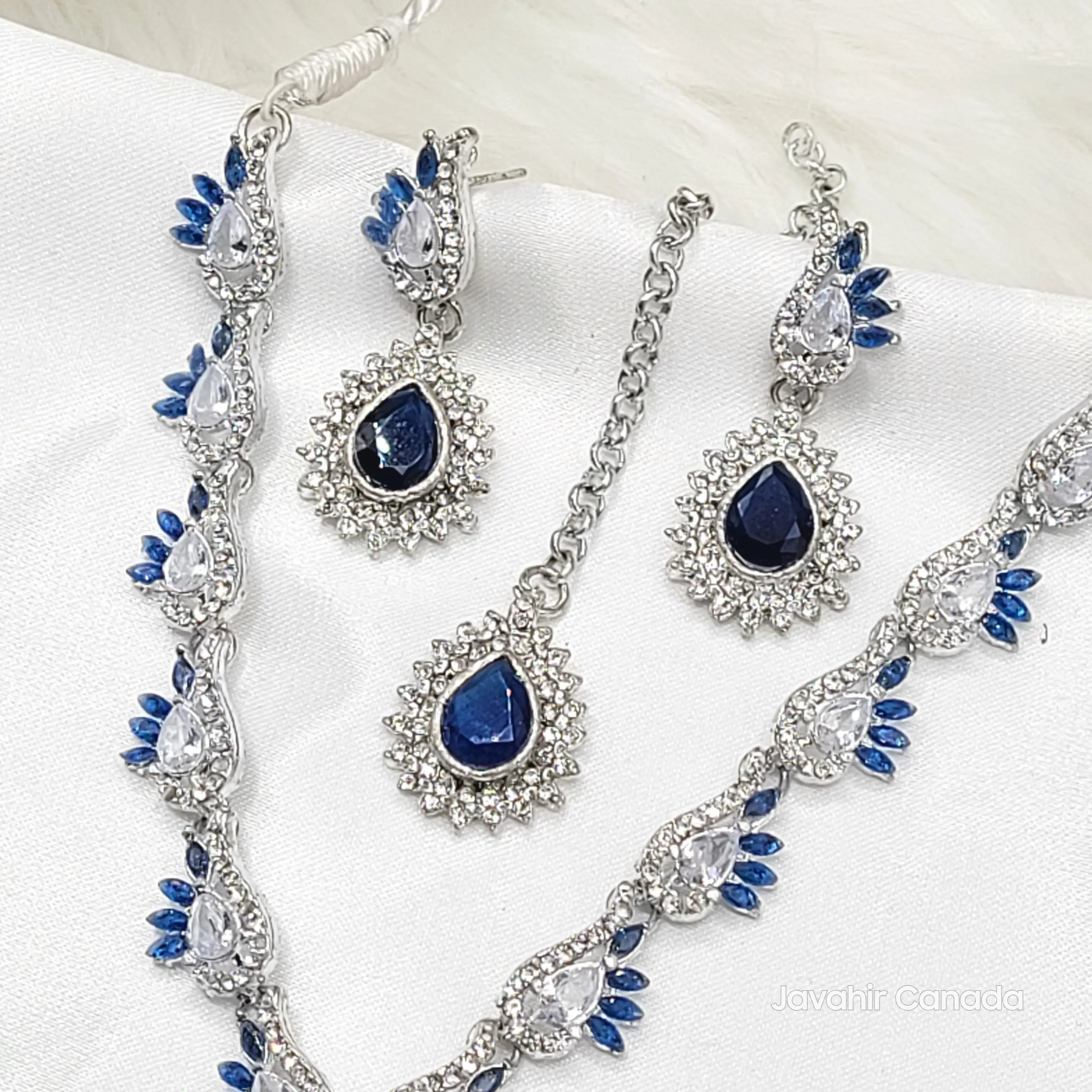 Jewelry set with blue stones and silver accents on a white background