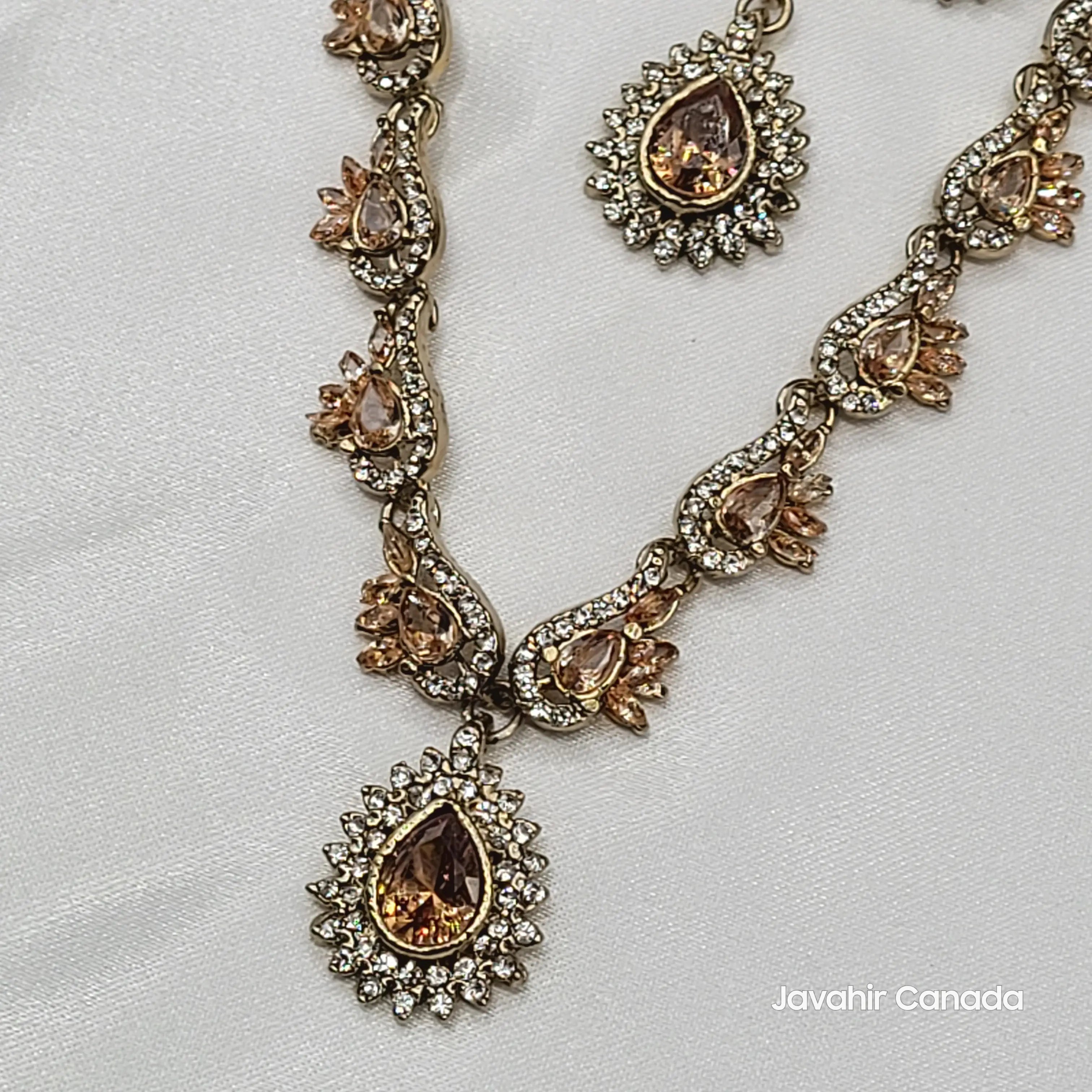 Jewelry set with necklace and earrings with champagne gemstones on a light gray background, featuring 'Javahir Canada' branding.