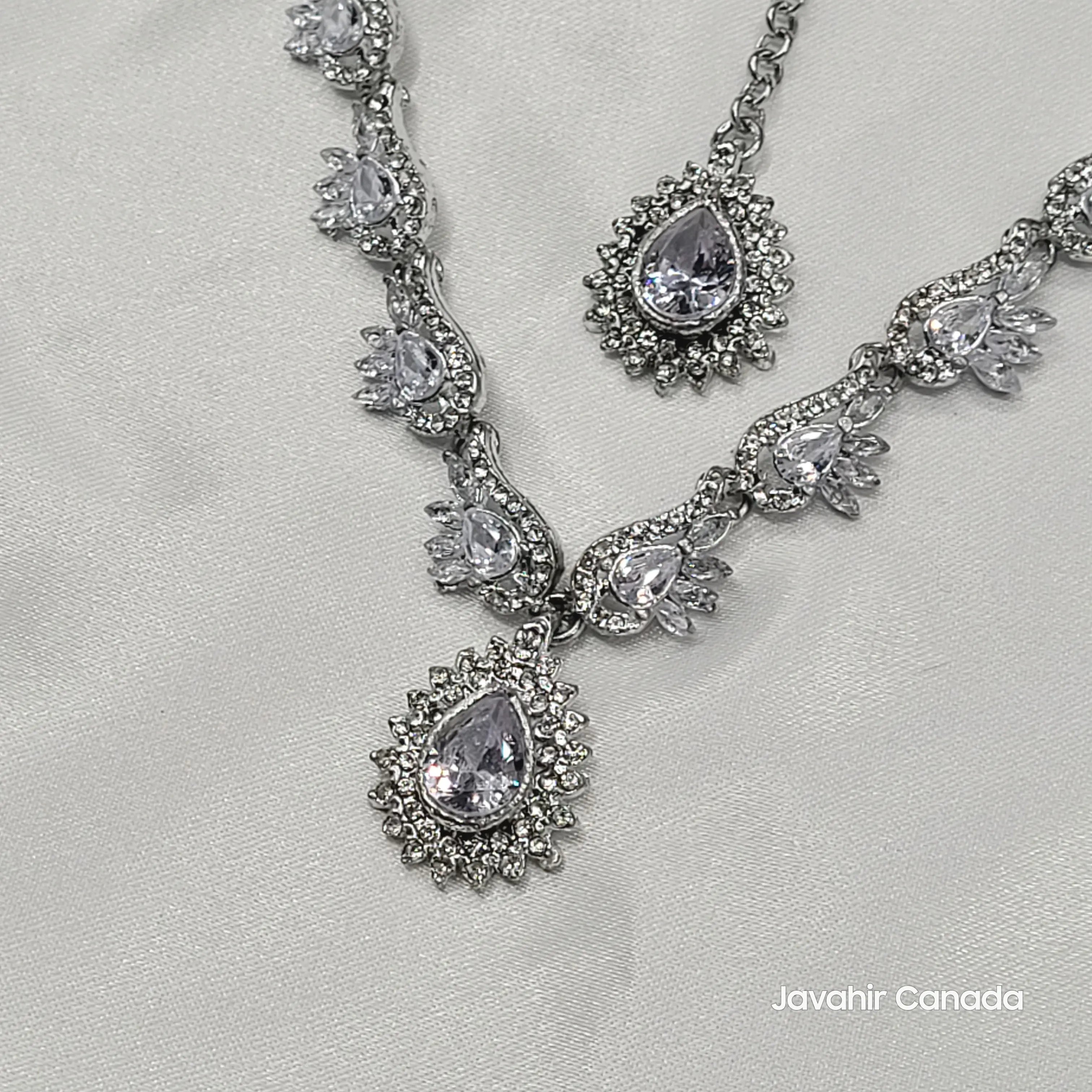 Silver necklace with teardrop-shaped gemstones on a light gray background