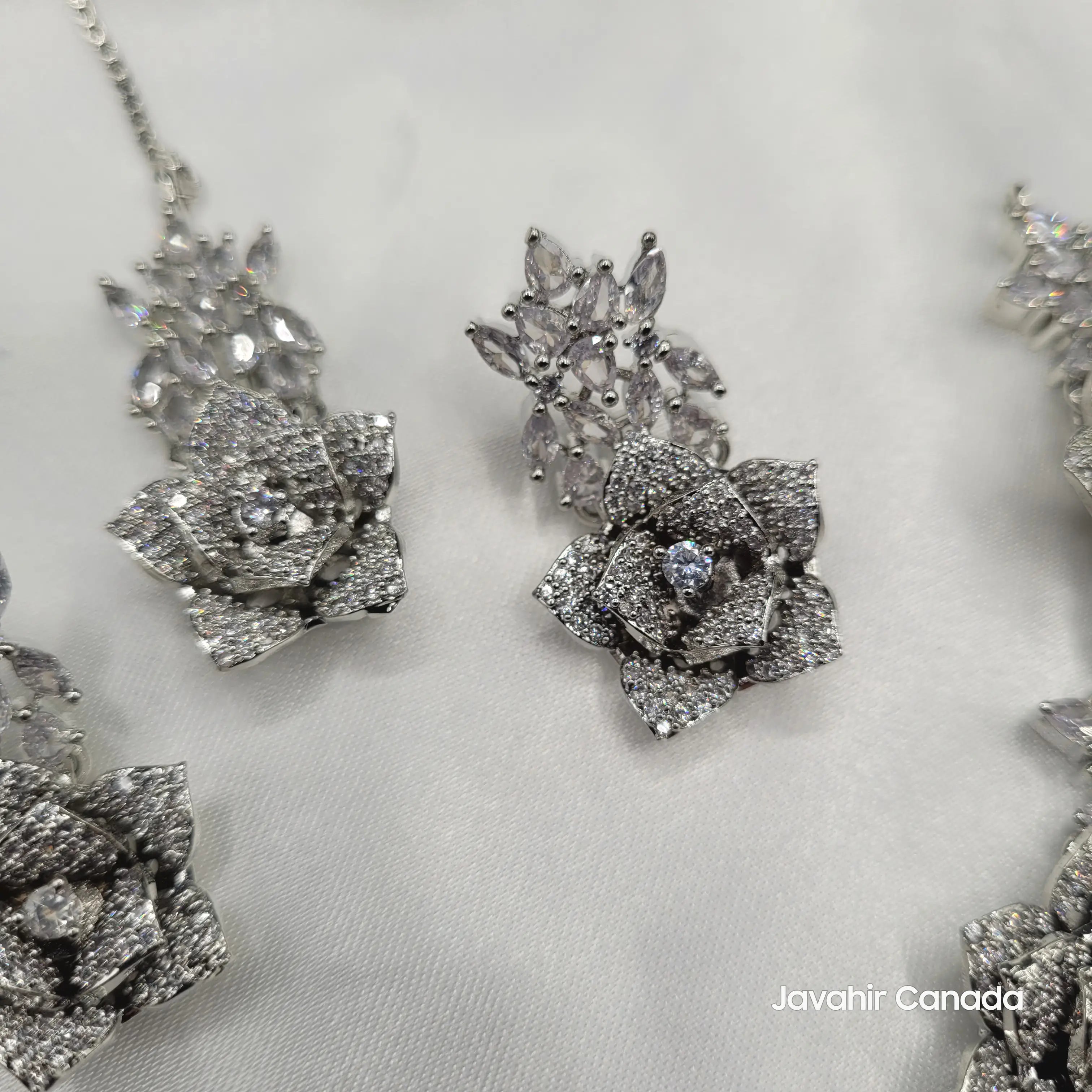 JV144 teeka and earrings displayed on a white fabric backdrop, showcasing clarity and brilliance of CZ stones.