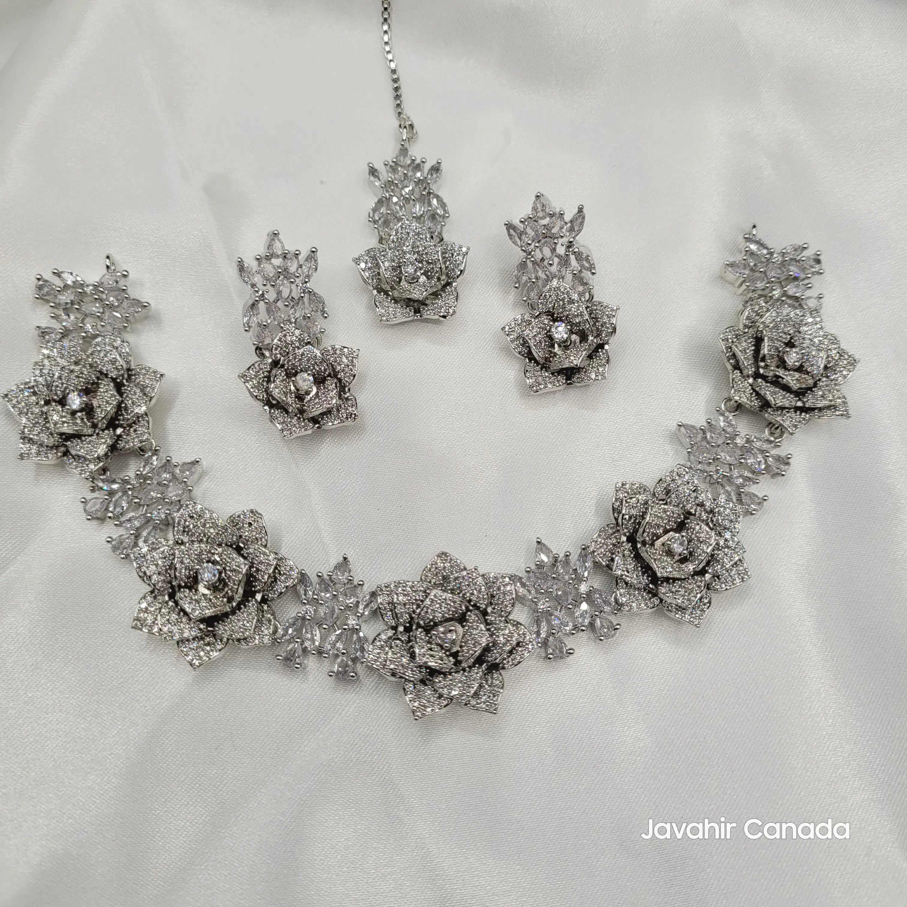 Full JV144 necklace set laid out, including earrings and tikka, on a satin backdrop for a luxurious presentation.