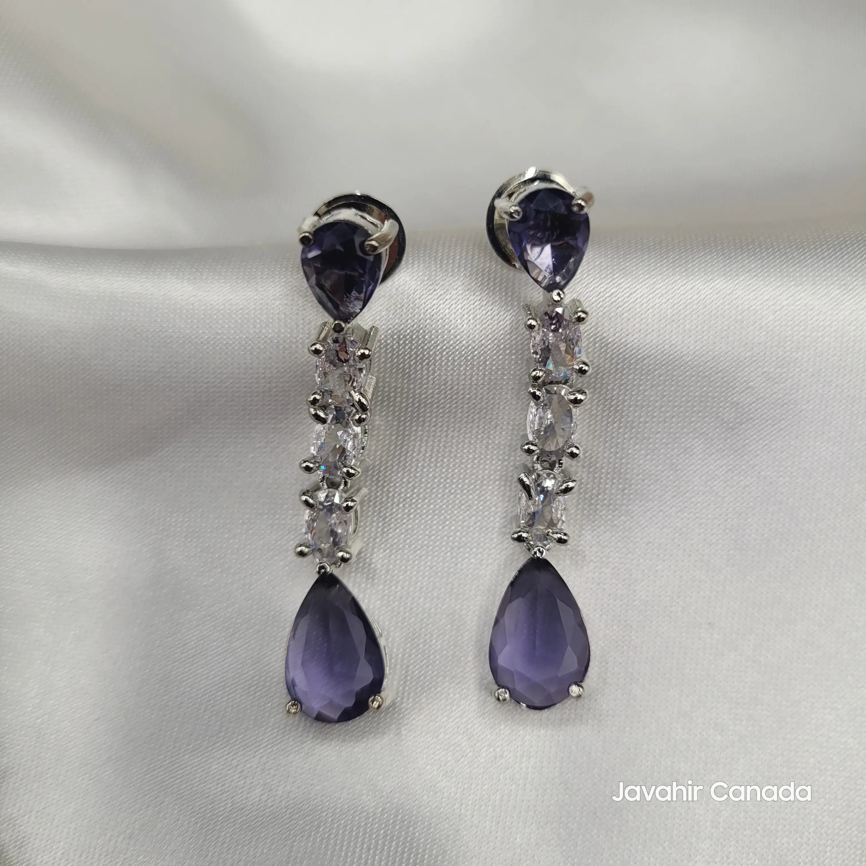 Close-up of JV145 lavender teardrop CZ earrings with silver base on satin.