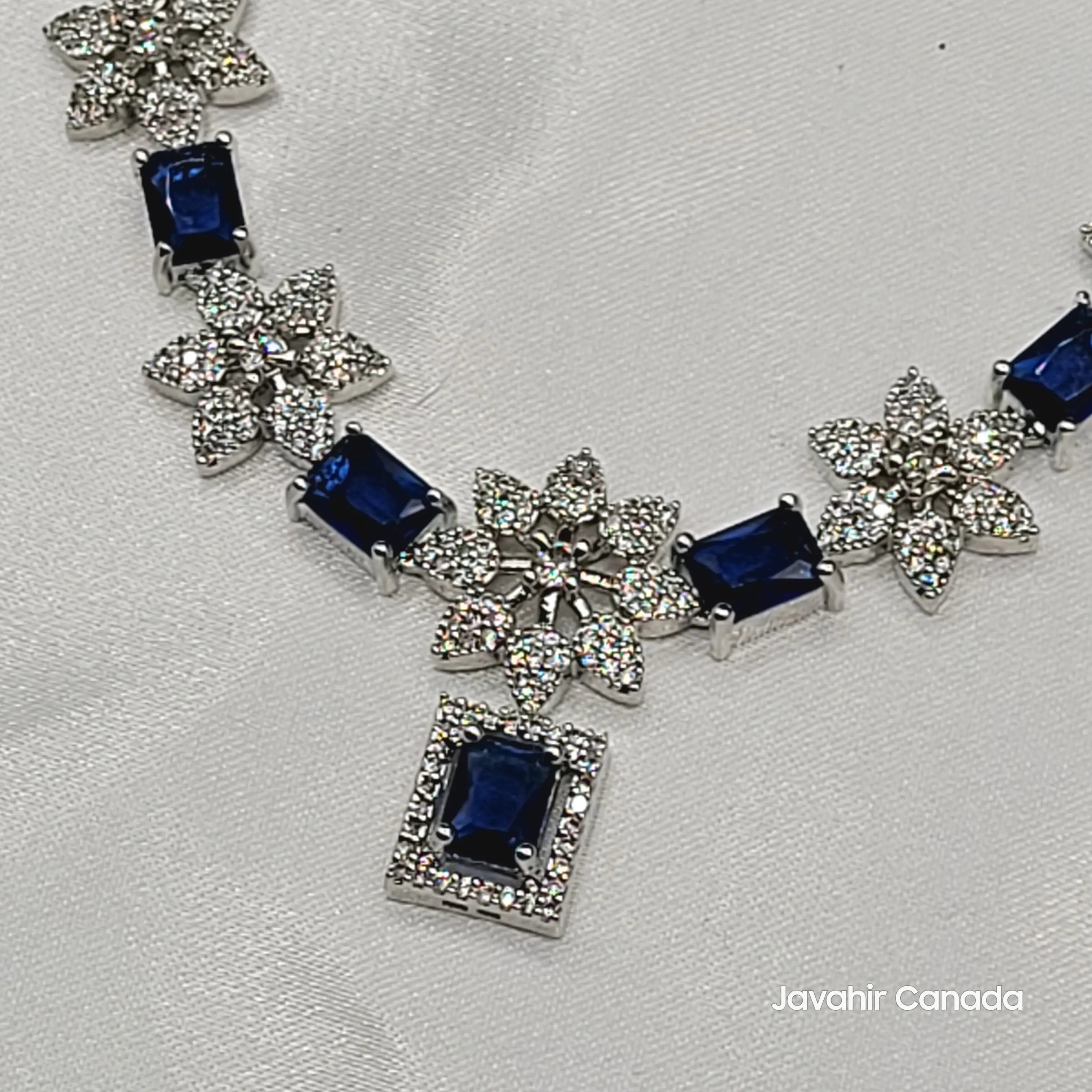 Silver necklace with sapphire blue gemstones on a light gray background