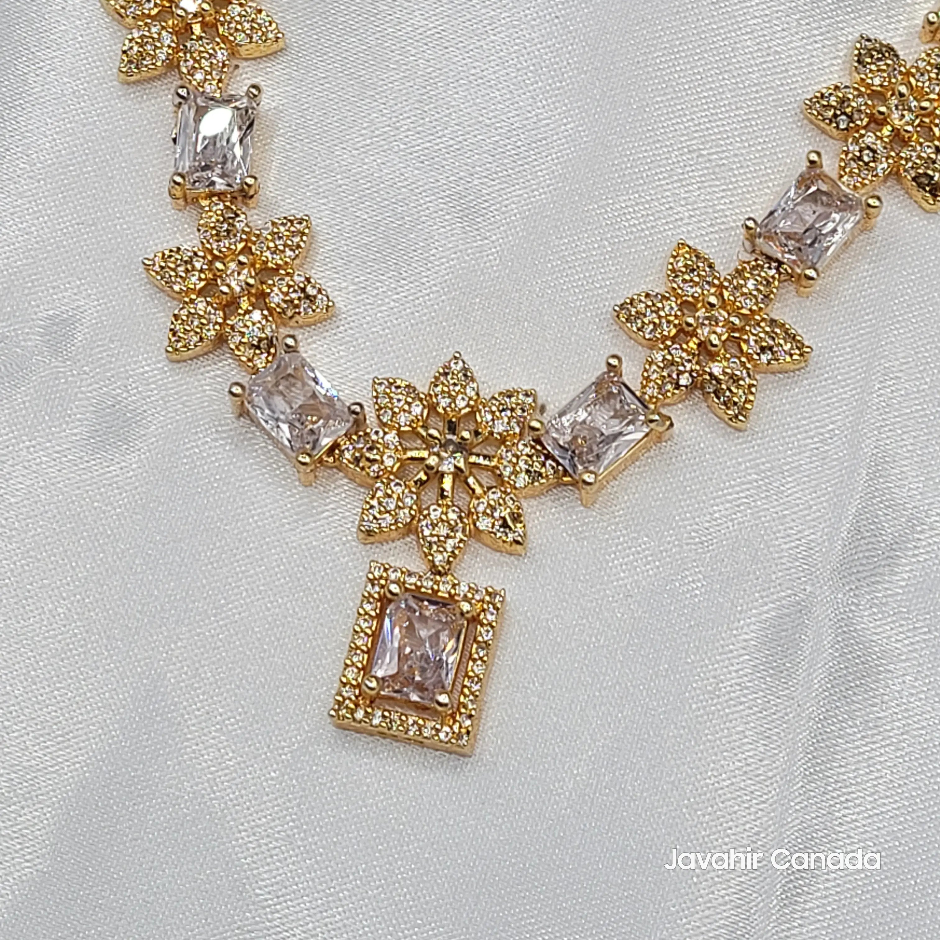 JV146 gold-plated floral necklace set with champagne CZ stones and matching earrings on satin background.