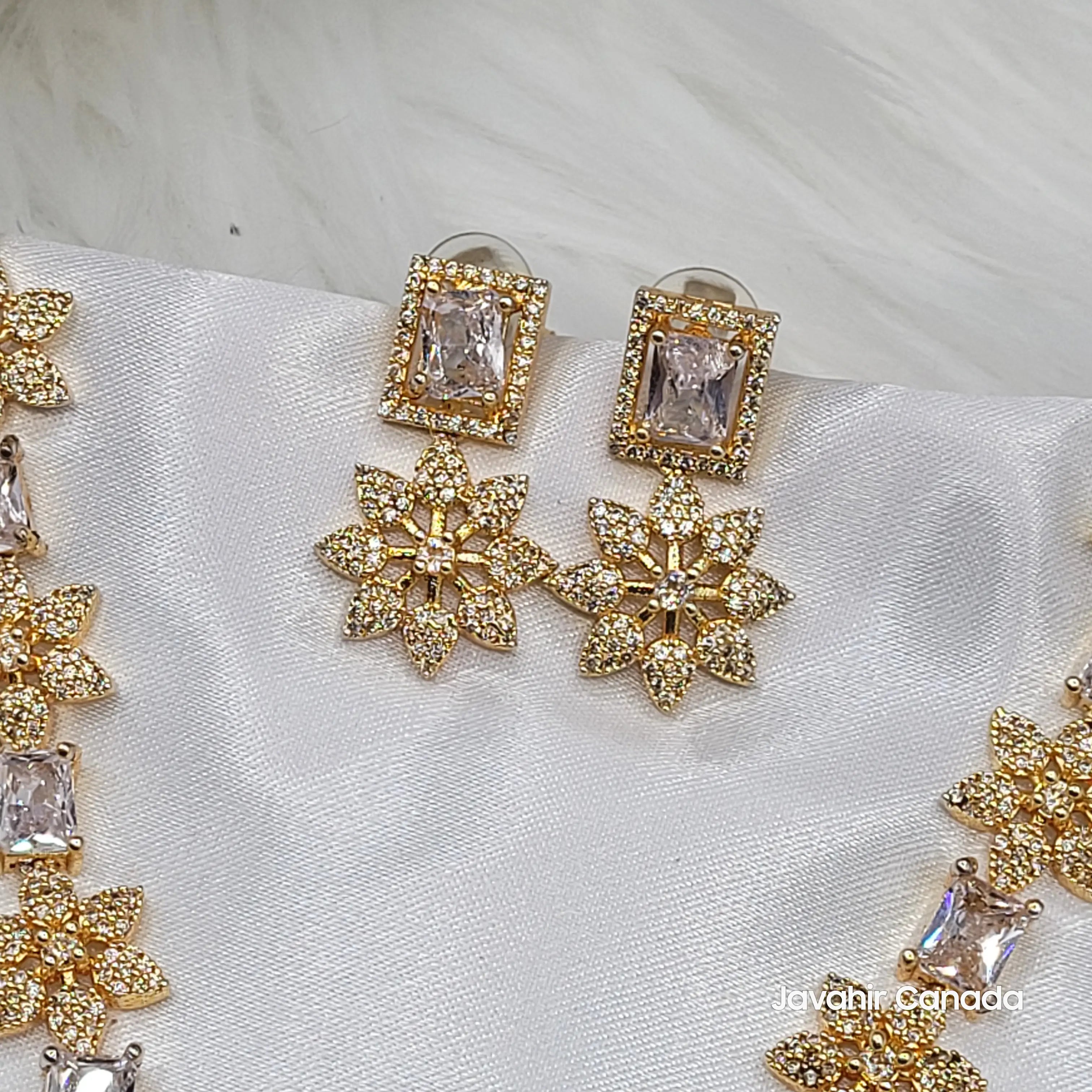 Close-up of JV146 champagne CZ earrings with floral drops on gold base.