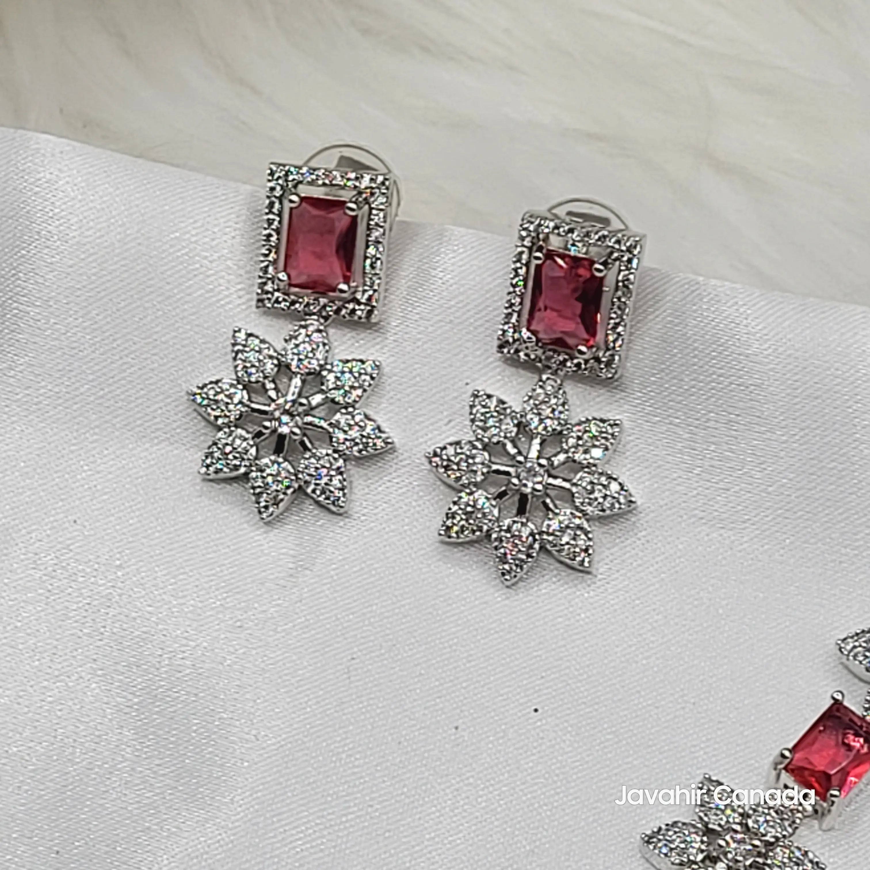 Close-up of JV146 ruby red CZ earrings with floral drops on silver base.