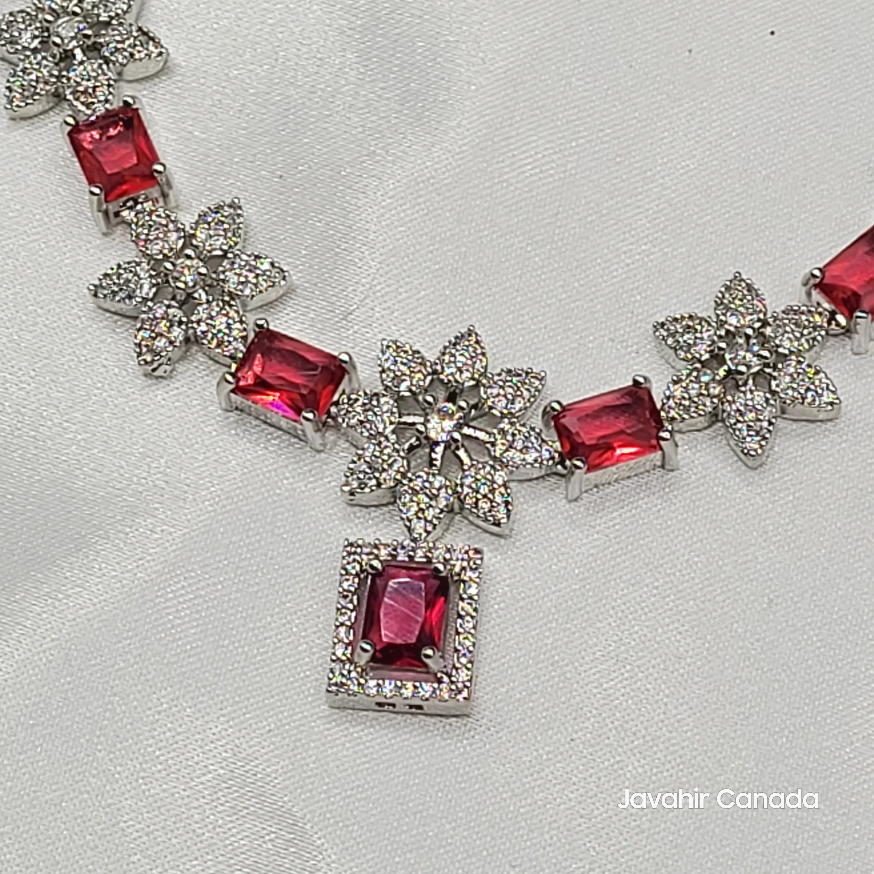 Close-up of JV146 ruby red CZ necklace set with floral drops on silver base.