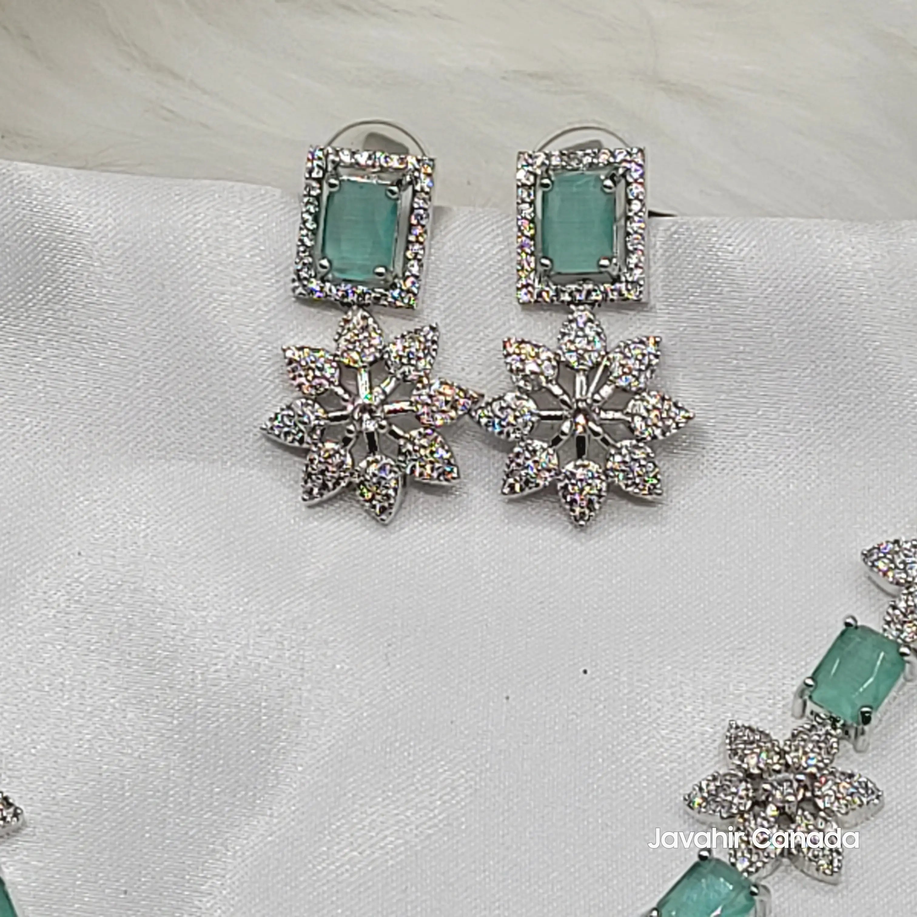 Close-up of mint green earrings from JV146 set featuring American diamond floral drops.
