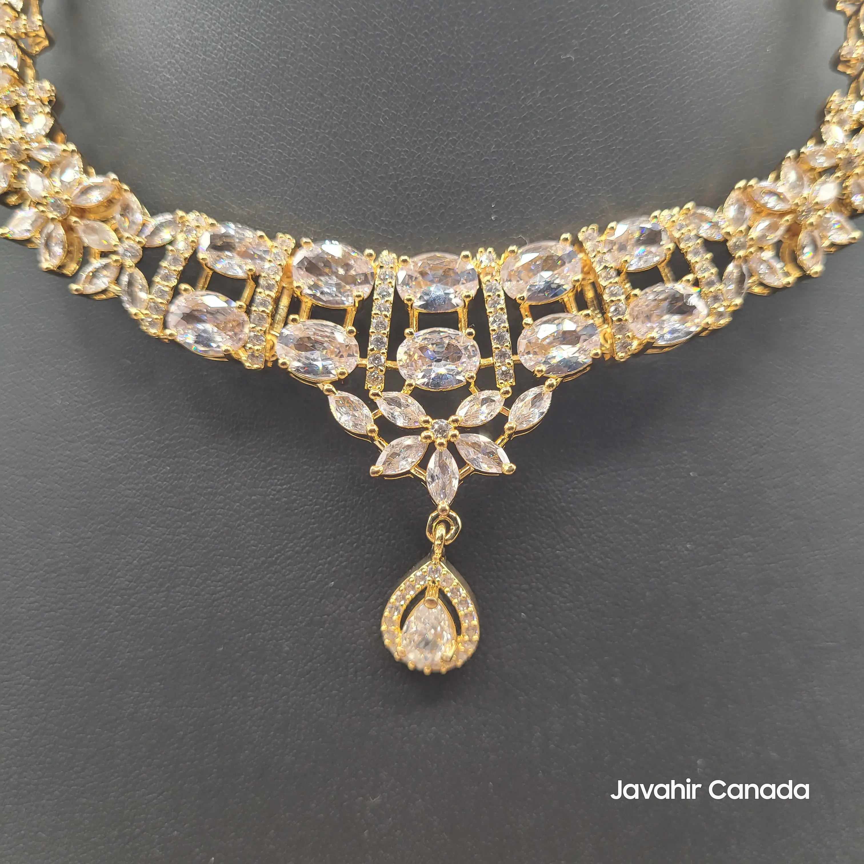 Detailed close-up of JV150 necklace in gold with clear zircon stones.