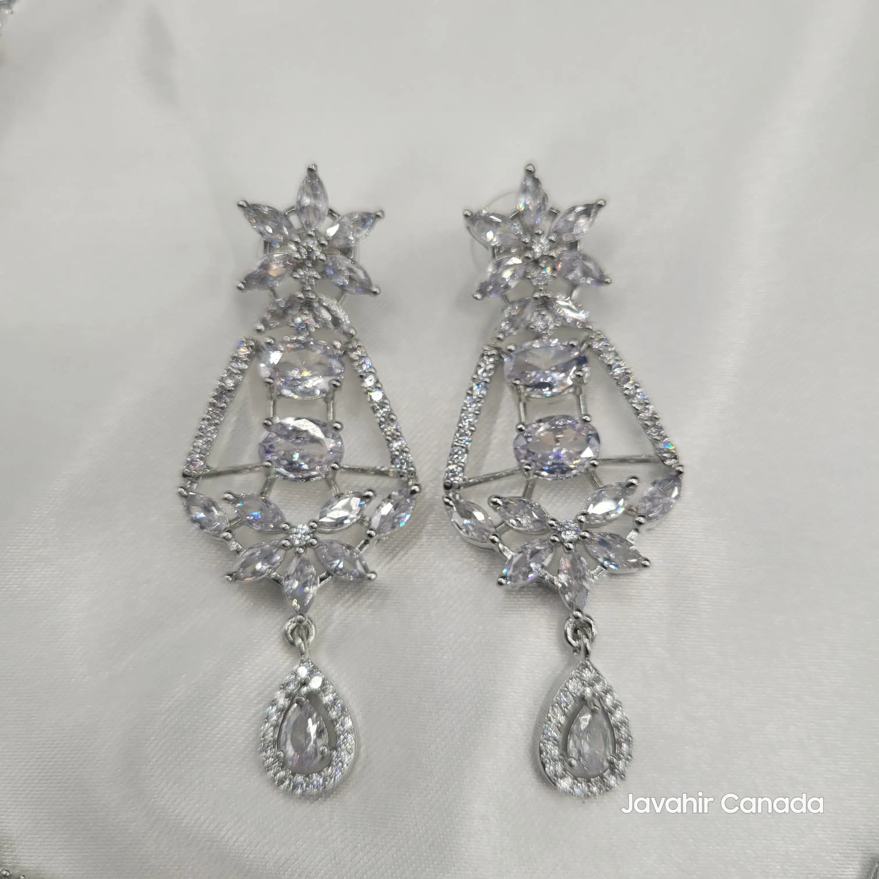 JV150 necklace set in silver with clear CZ stones and floral teardrop earrings on white satin.