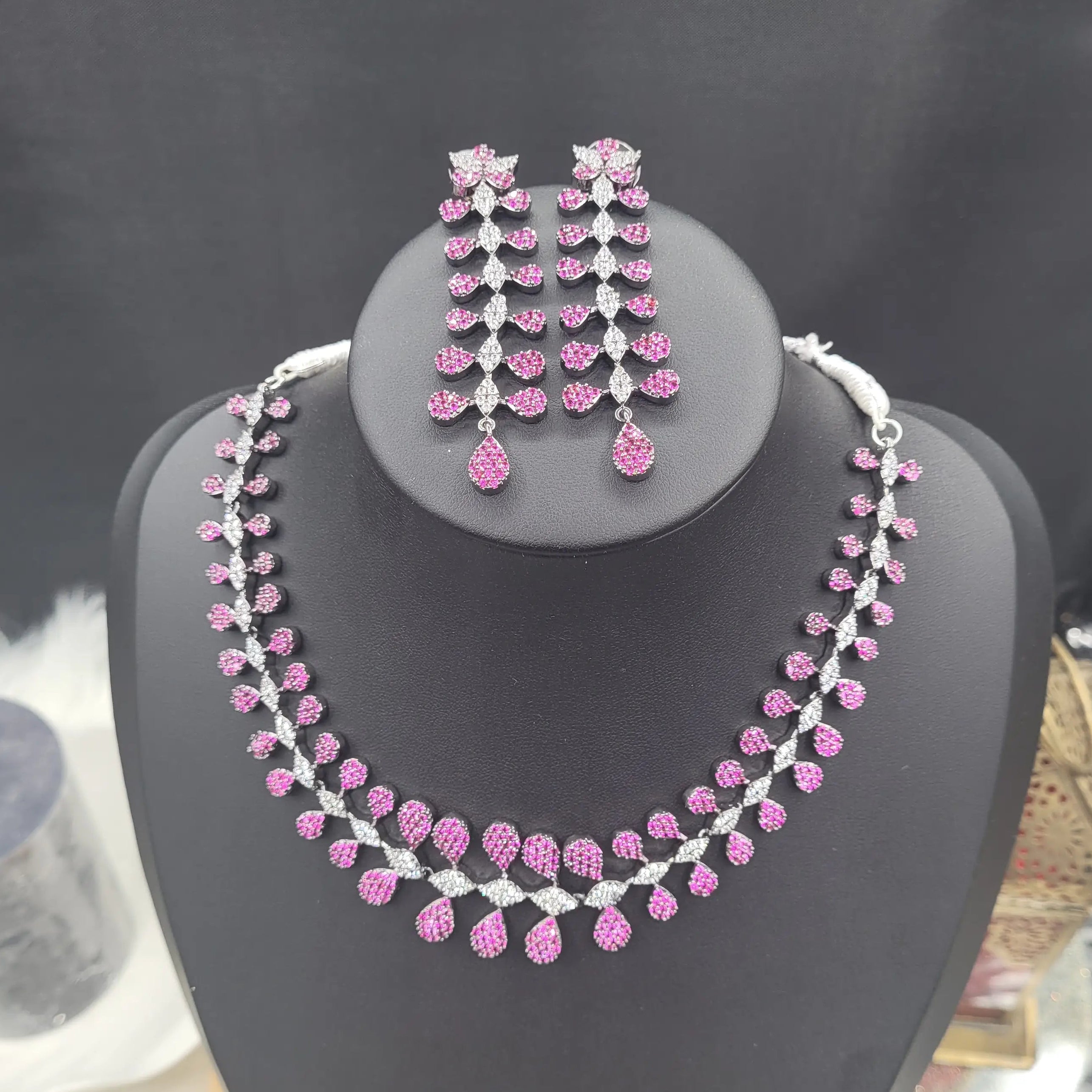 Complete pink zircon necklace set JV152 with matching earrings displayed on a black stand, ideal for bridal or formal wear.