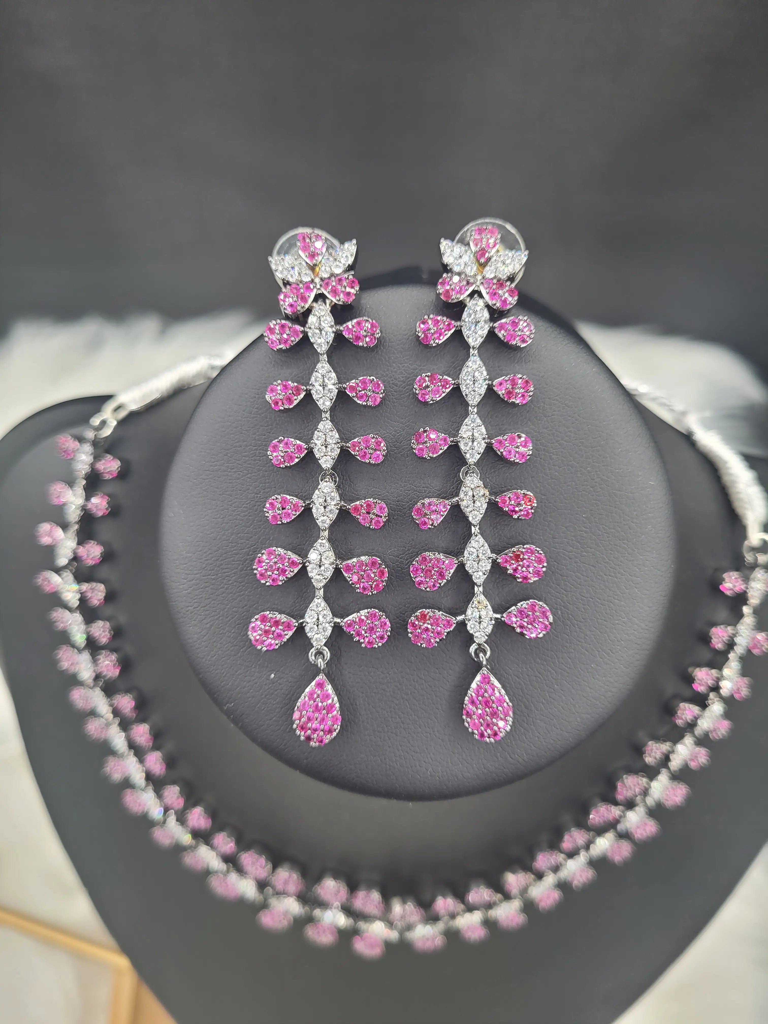 Close-up view of JV152 pink zircon necklace set with long floral earrings featuring silver and pink CZ teardrops.