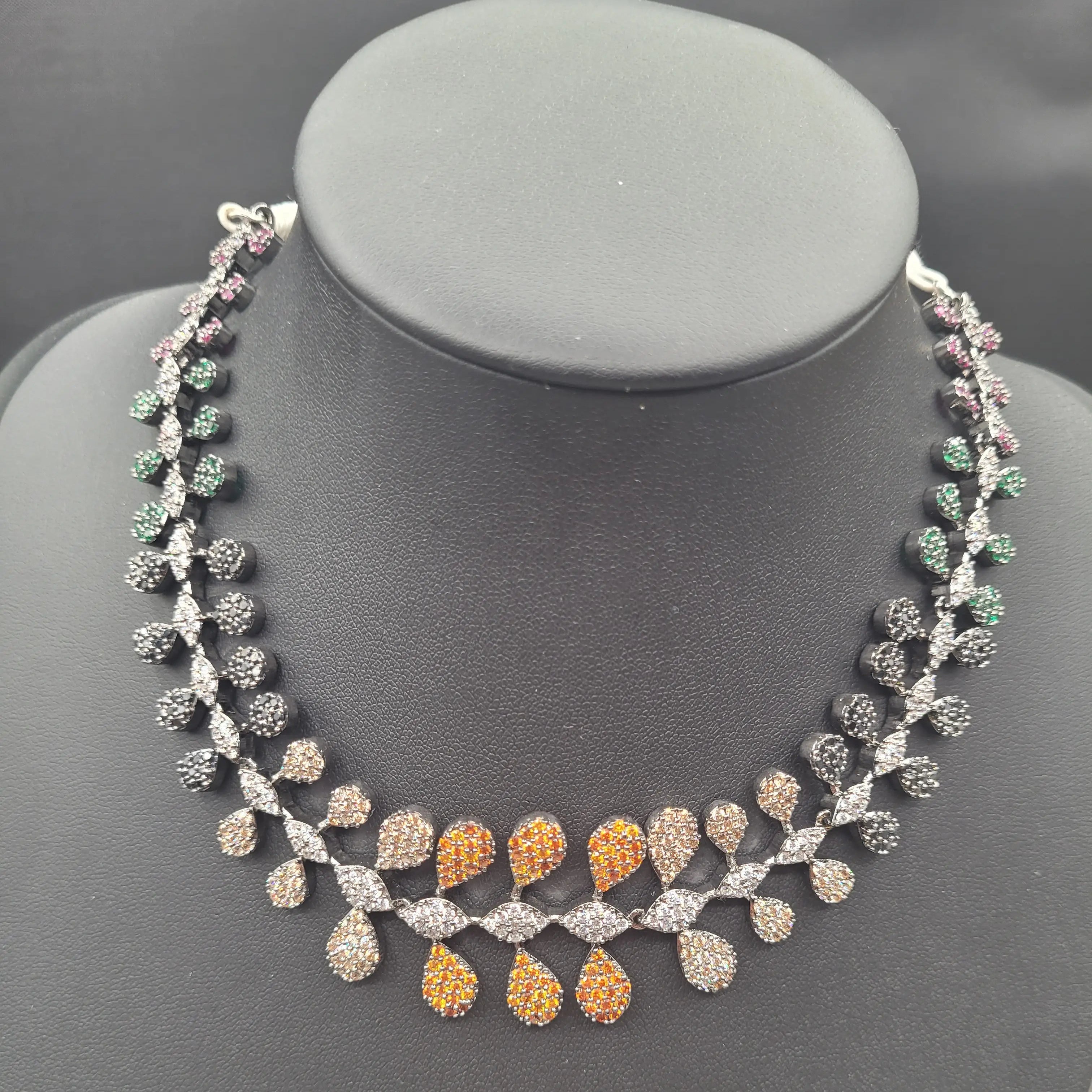 Front view of the JV152 multicolour necklace on black bust, highlighting the central orange and neutral CZ stones.