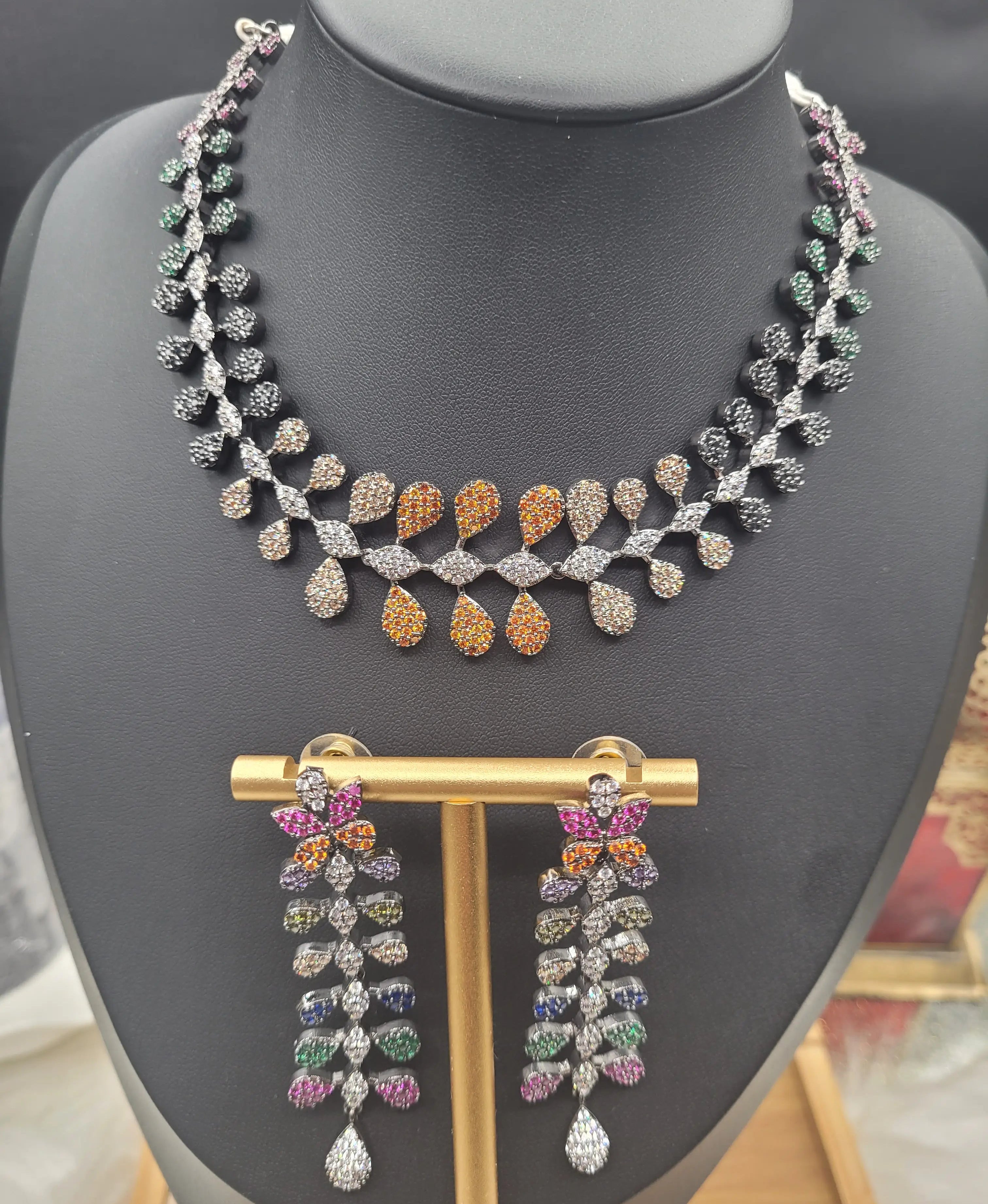 JV152 complete multicolour necklace set with earrings displayed on gold earring stand and necklace on black mannequin.