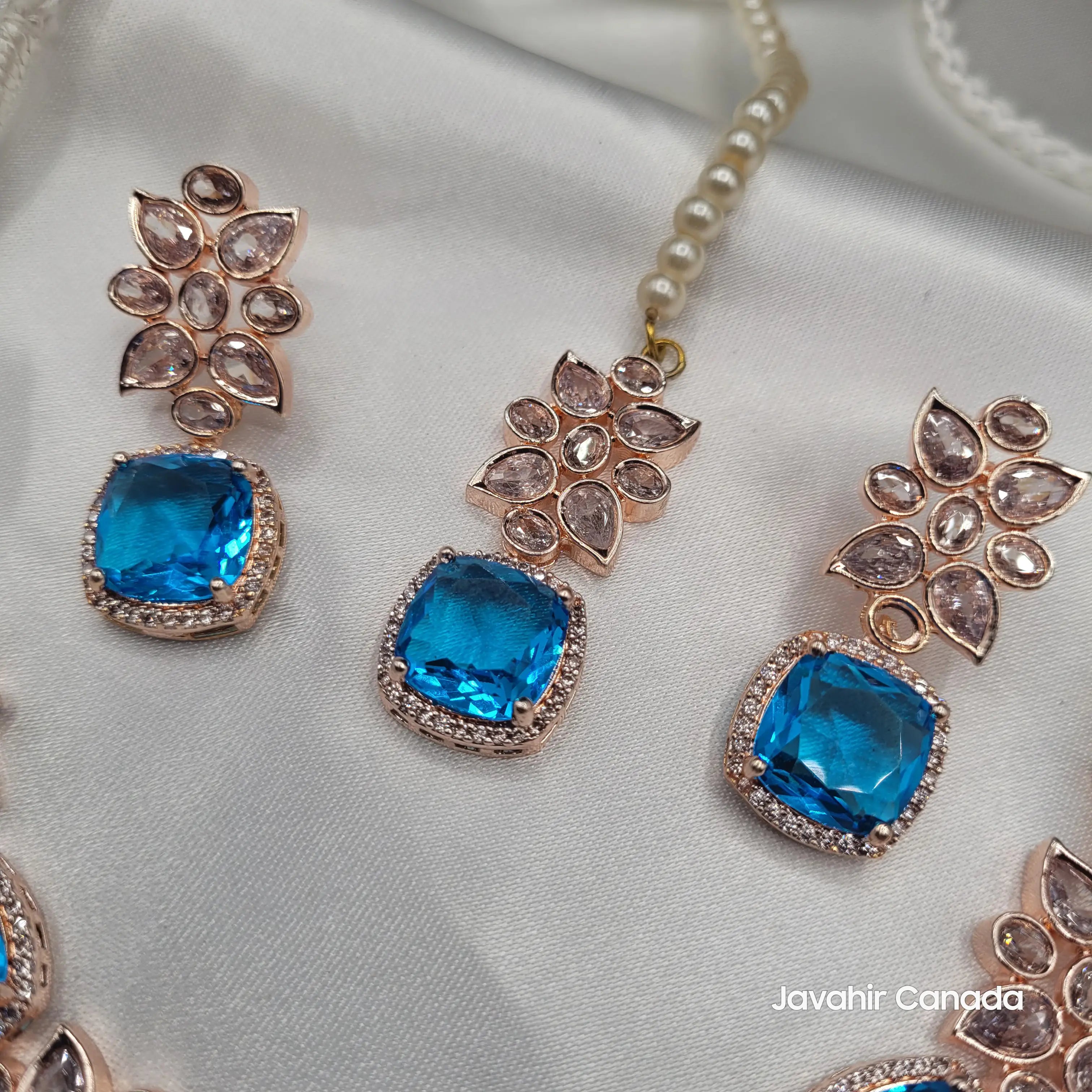 Close-up of blue zircon earrings and tikka from the JV153 set, showcasing floral CZ accents and rose gold detailing.