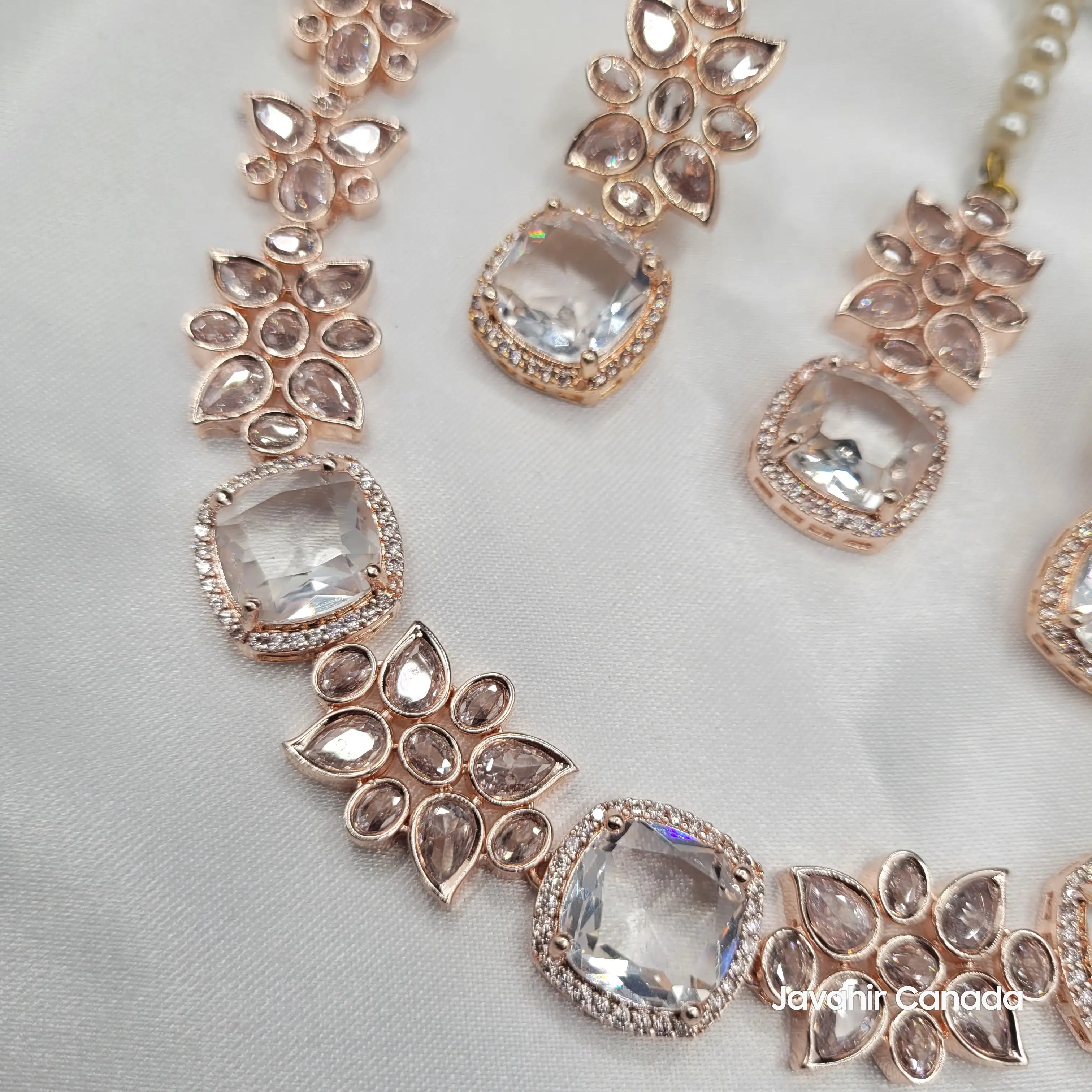 Rose gold necklace with clear gemstones on a light gray background