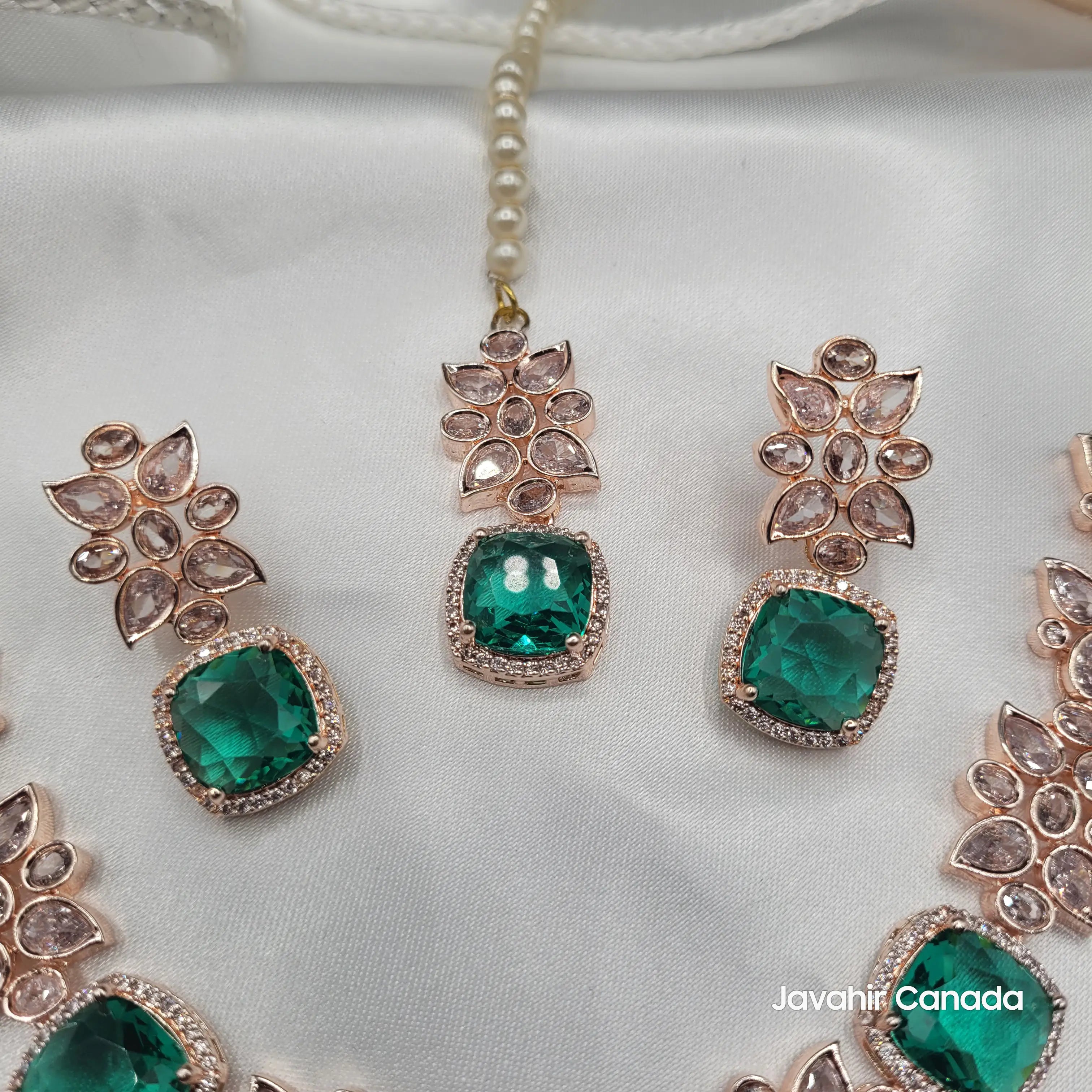 Detailed view of emerald green zircon earrings and tikka from the JV153 set with floral CZ accents and rose gold finish.