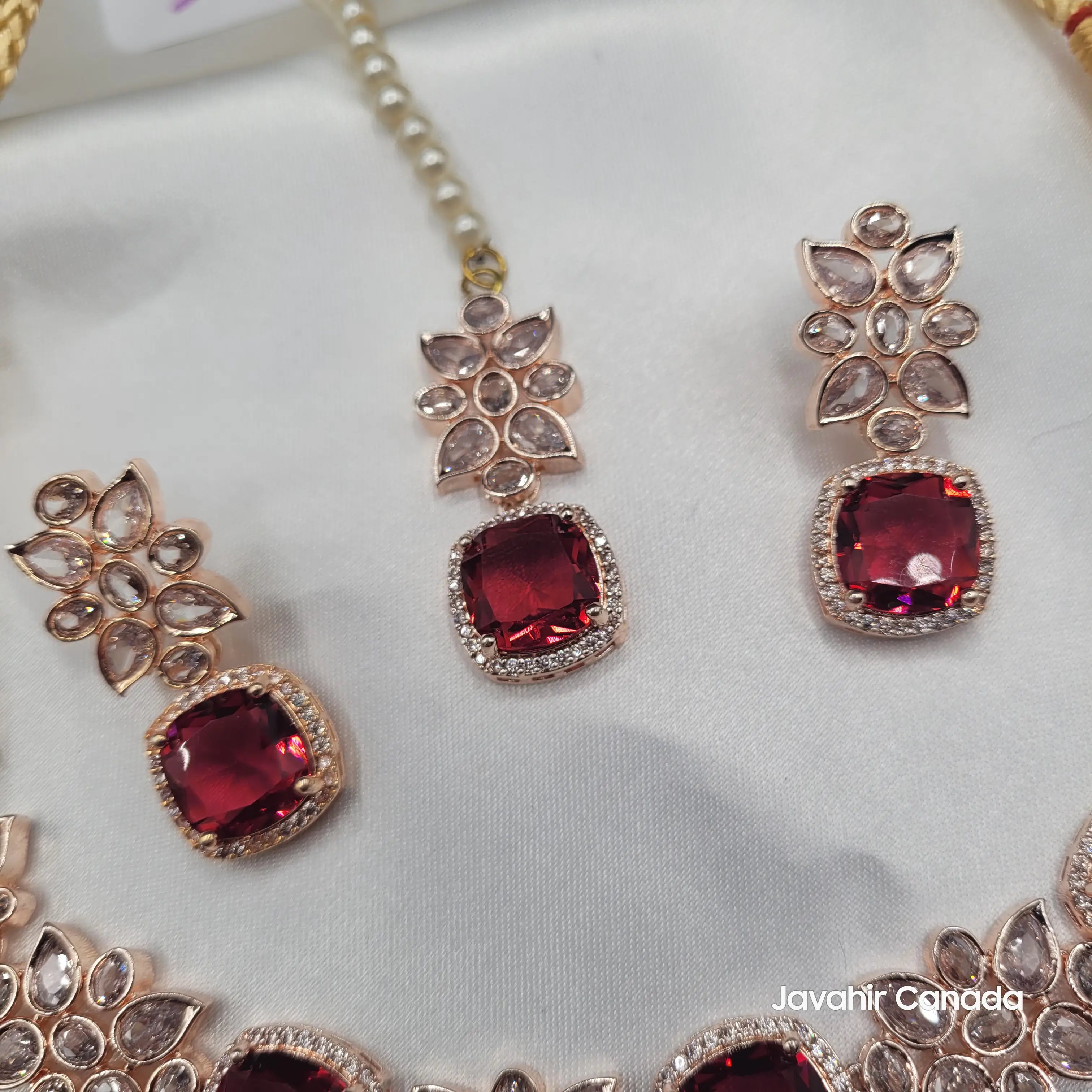 Close-up of ruby red zircon centerpiece and earrings from JV153, surrounded by rose gold floral CZ work and clear zircon petals.
