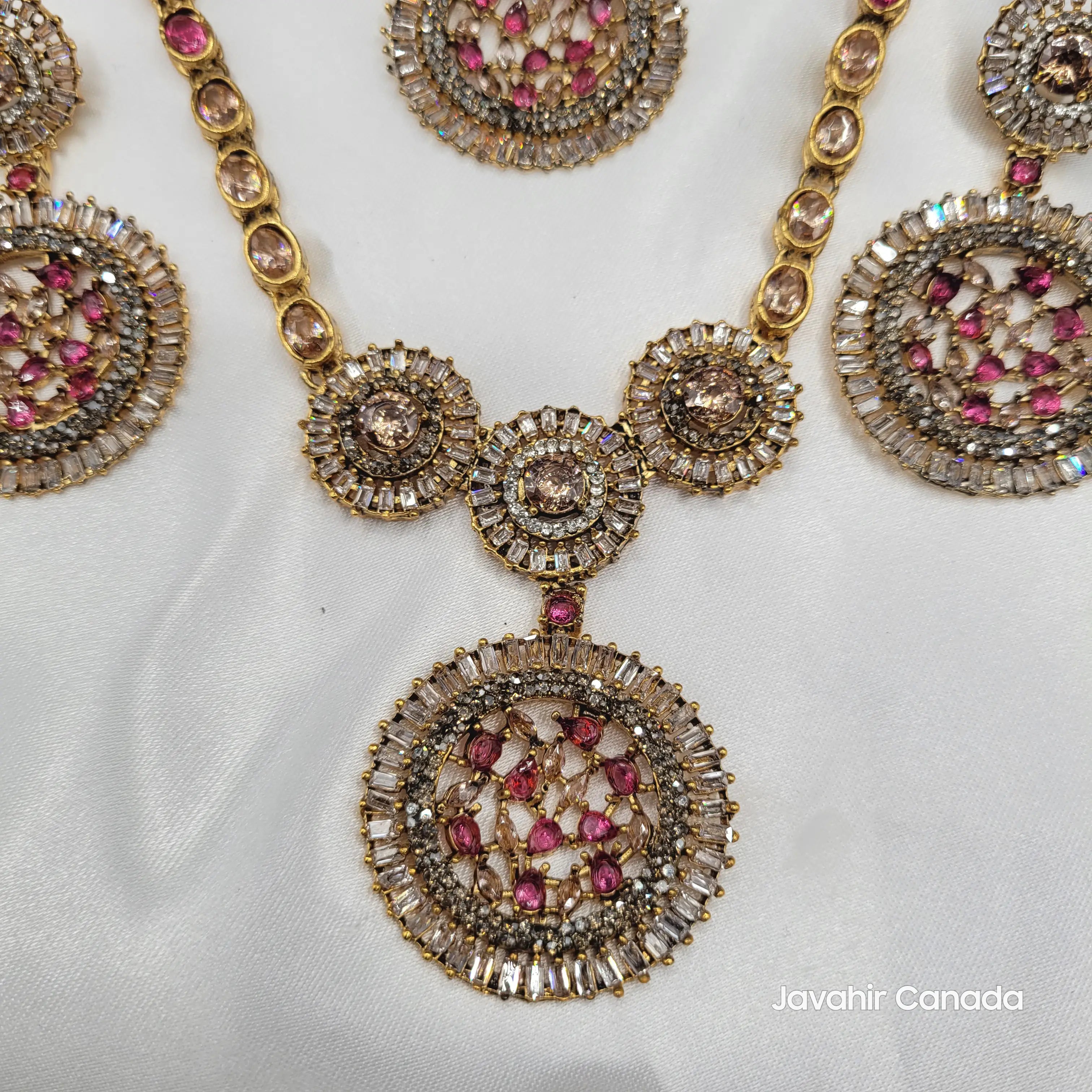 Top close-up of pink pendant with CZ baguette framing and colored stones