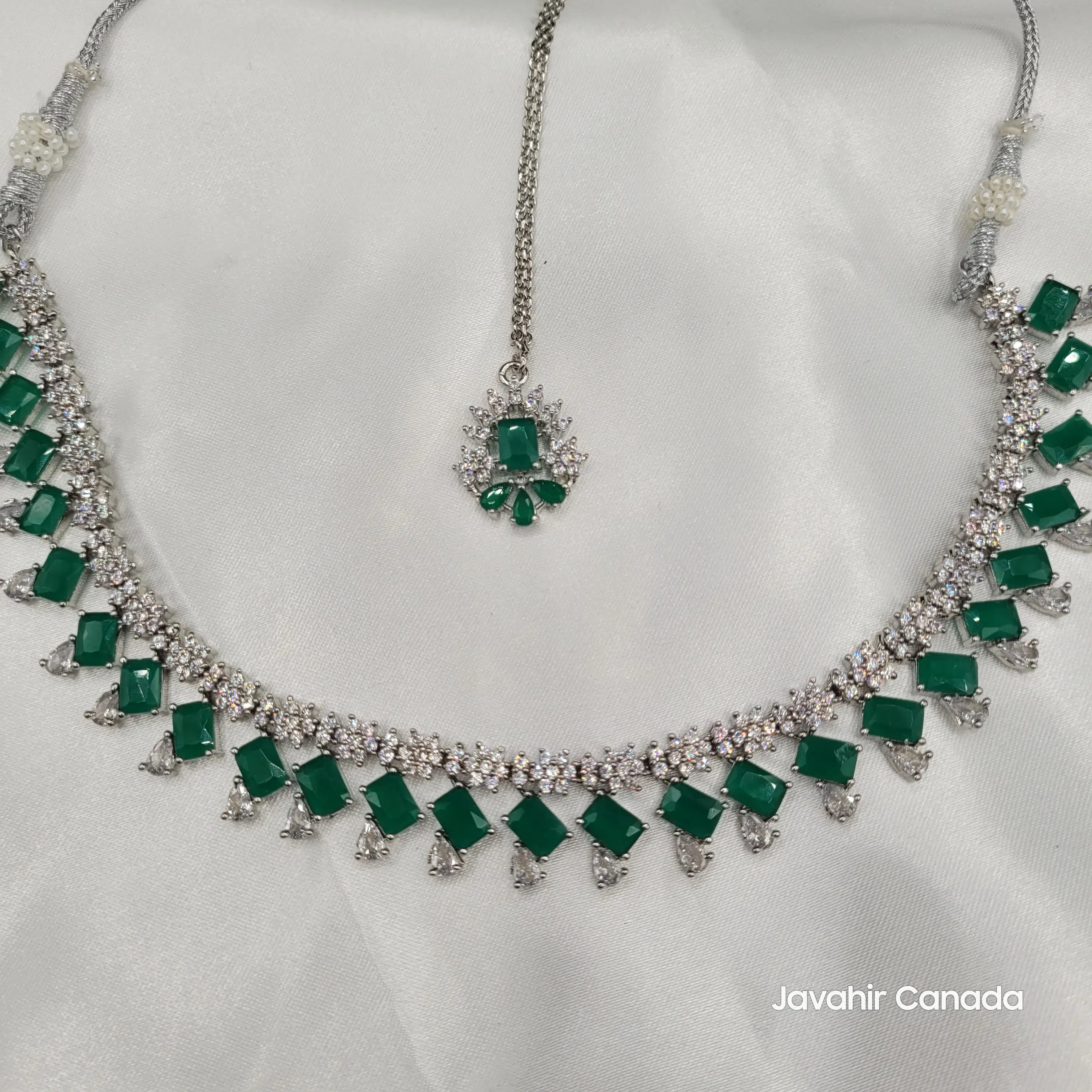 Top view of JV19 showcasing the layout of green stones and white CZ settings with matching maang tikka.