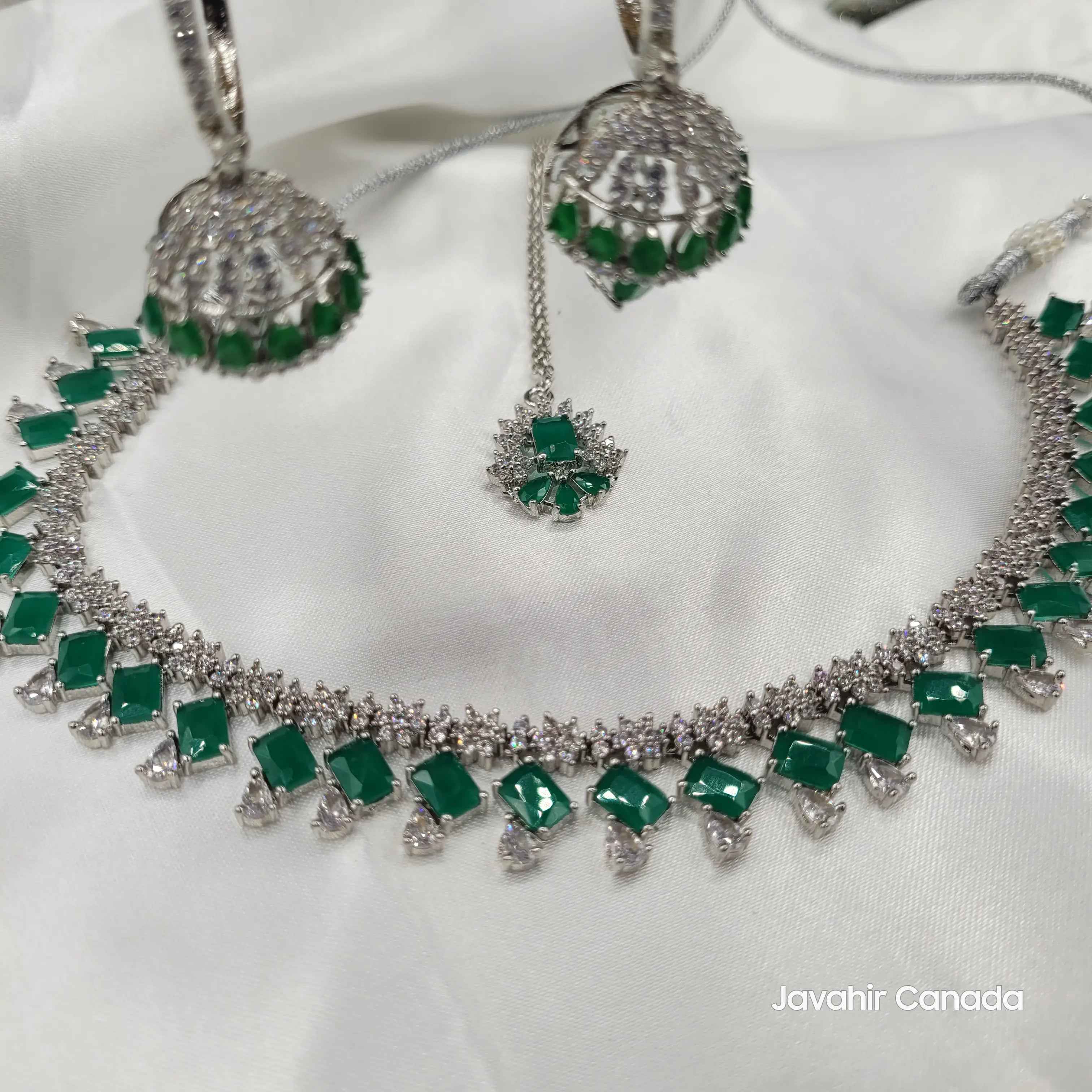 JV19 full set including necklace, earrings, and maang tikka displayed flat with silver base and green detailing.