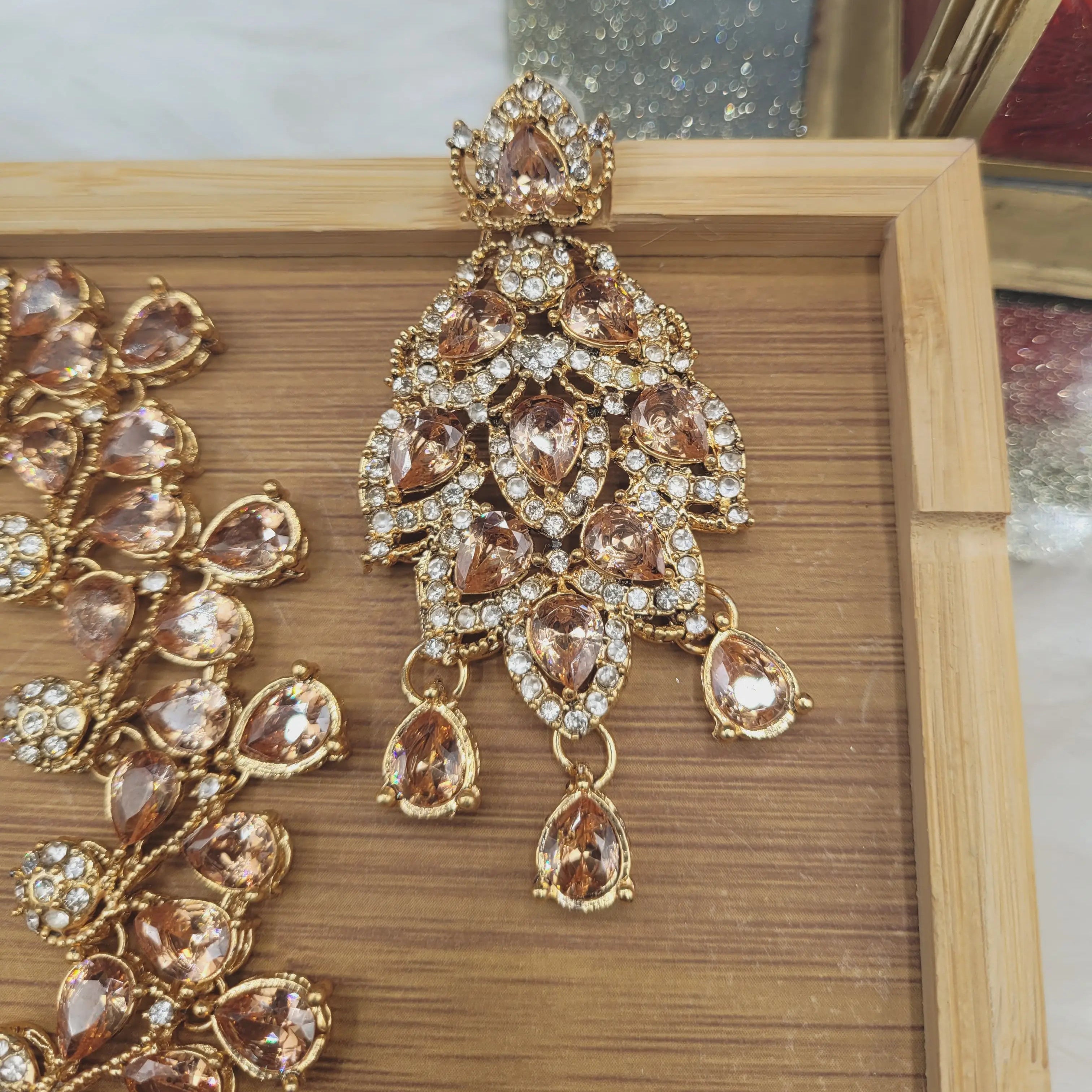 Close-up of JV20 champagne earring with golden tone CZ stones