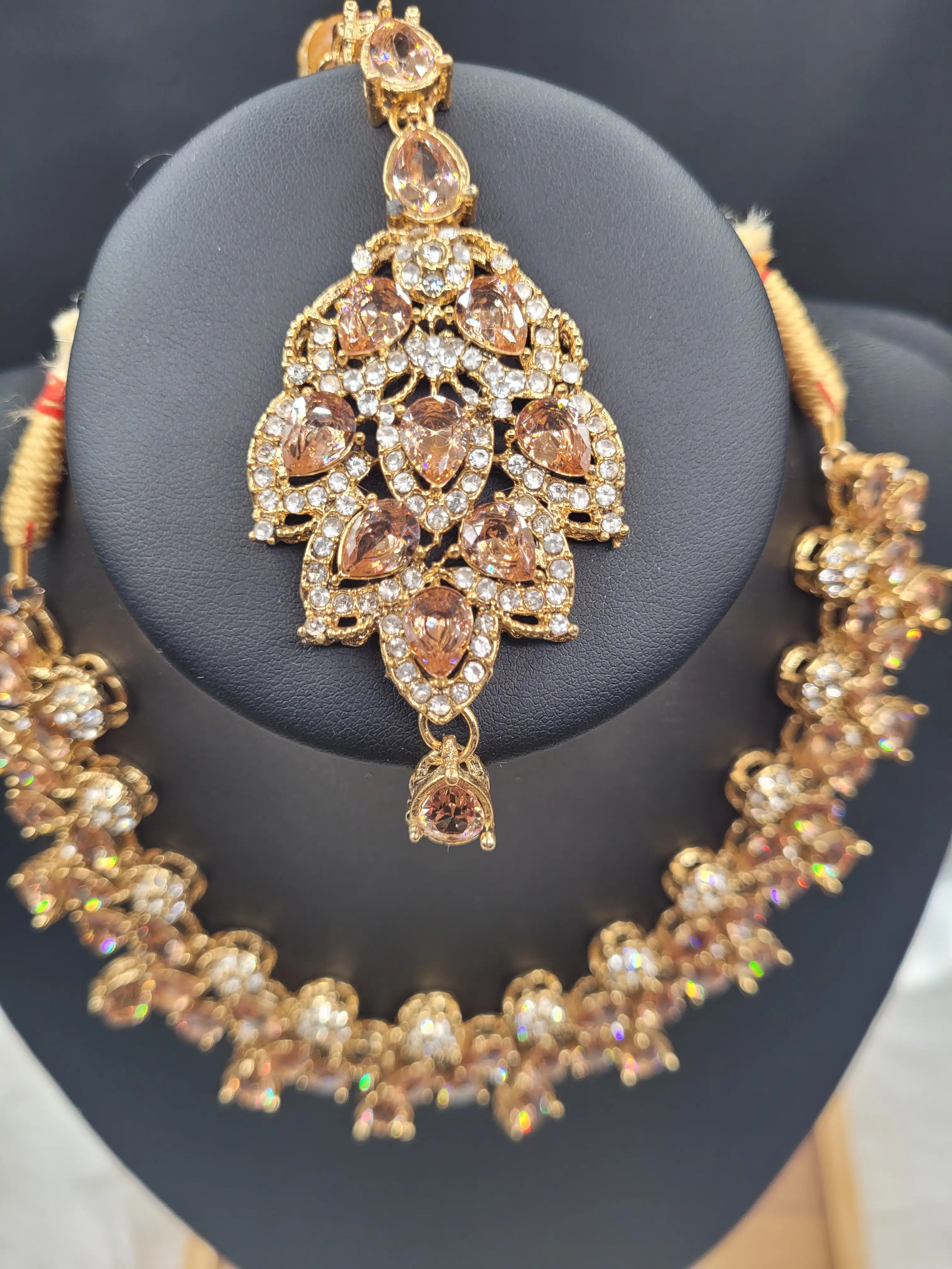 Close-up of JV20 champagne tikka with golden tone CZ stones