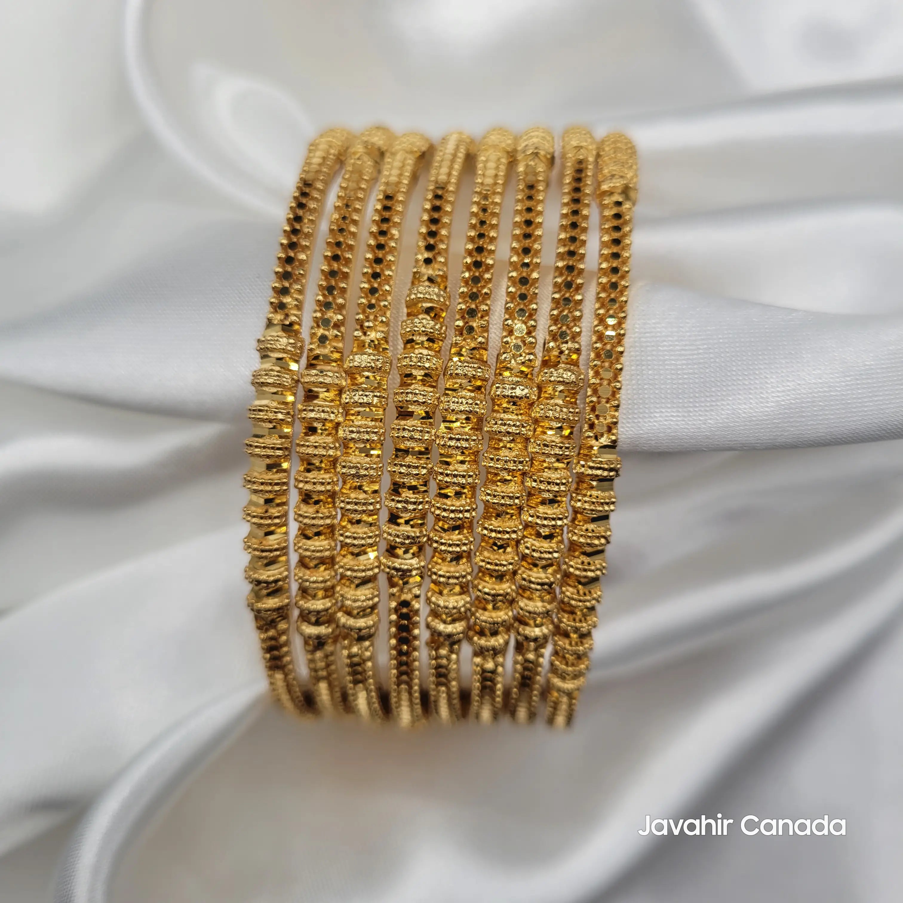 Elegant gold bangles set with linear detailing and intricate beadwork