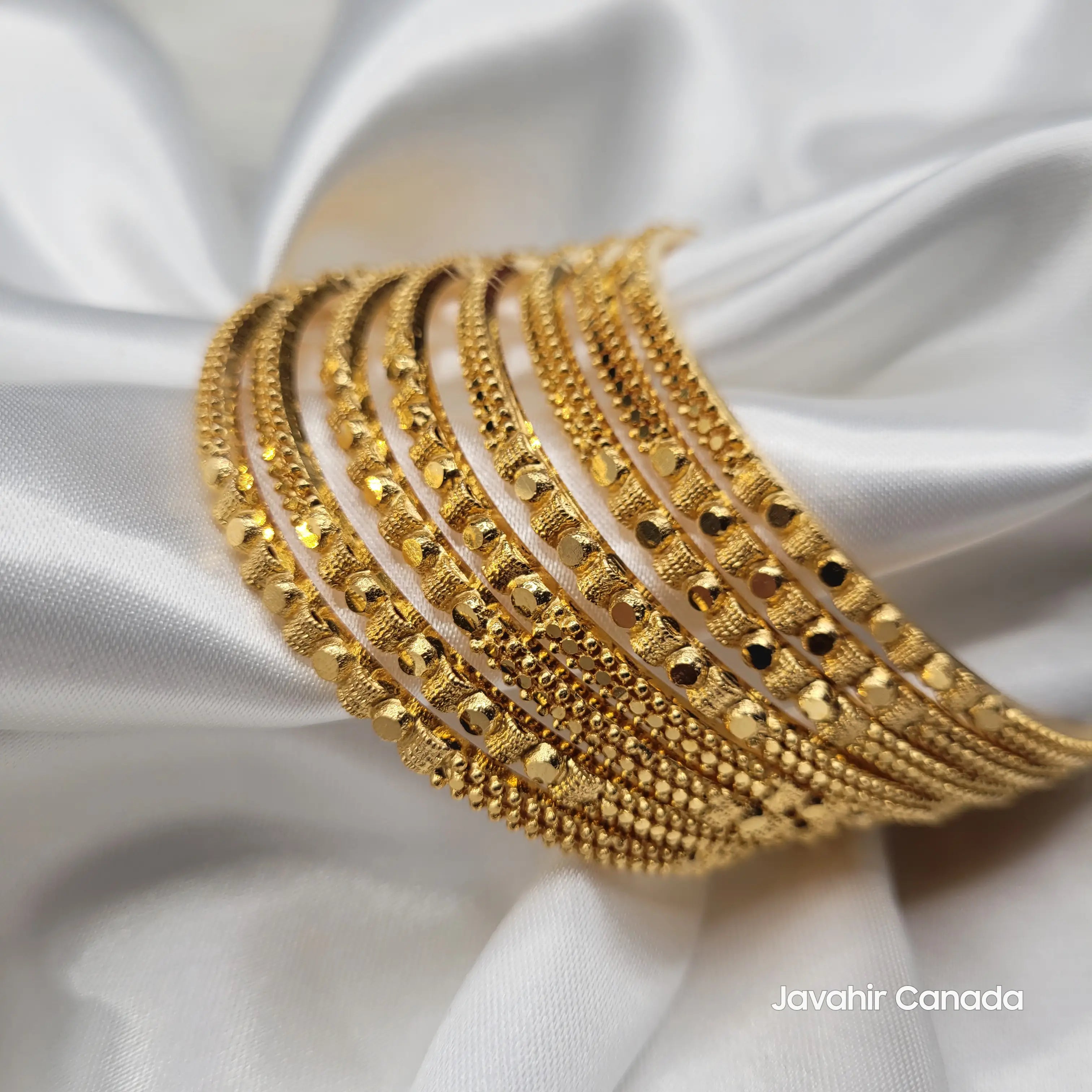 Close-up of 22K gold bangles with polished, detailed surface