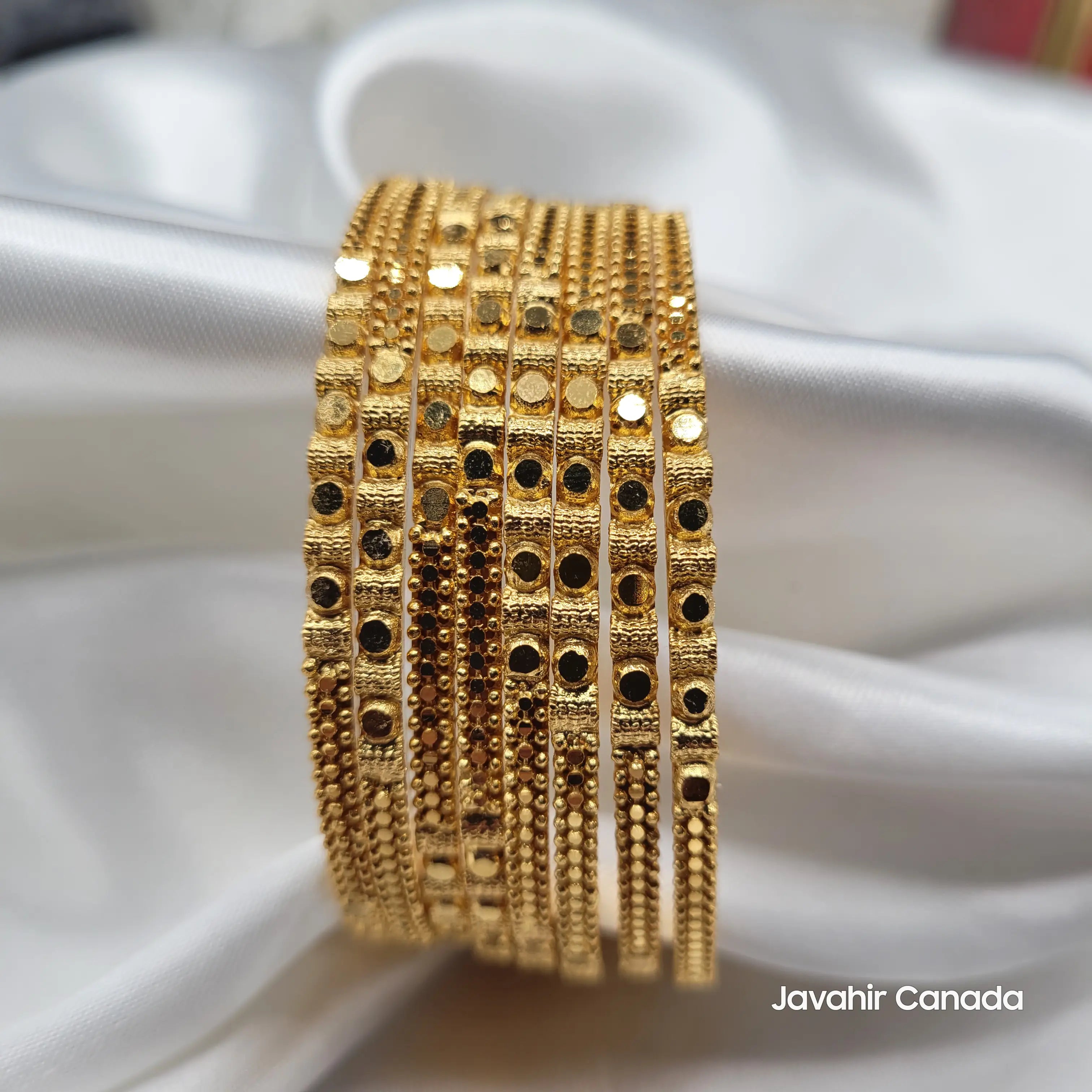 Front view of JV3034 textured gold bangles in a stack of 8