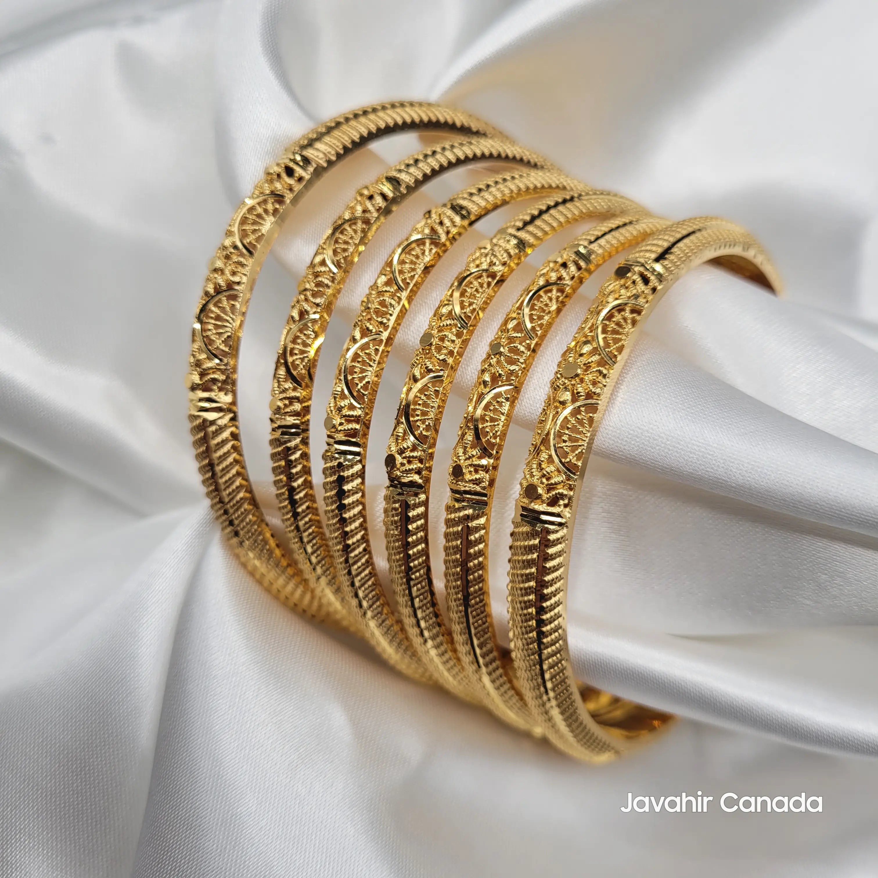 Close-up of 22K gold plated bangles featuring intricate detailing