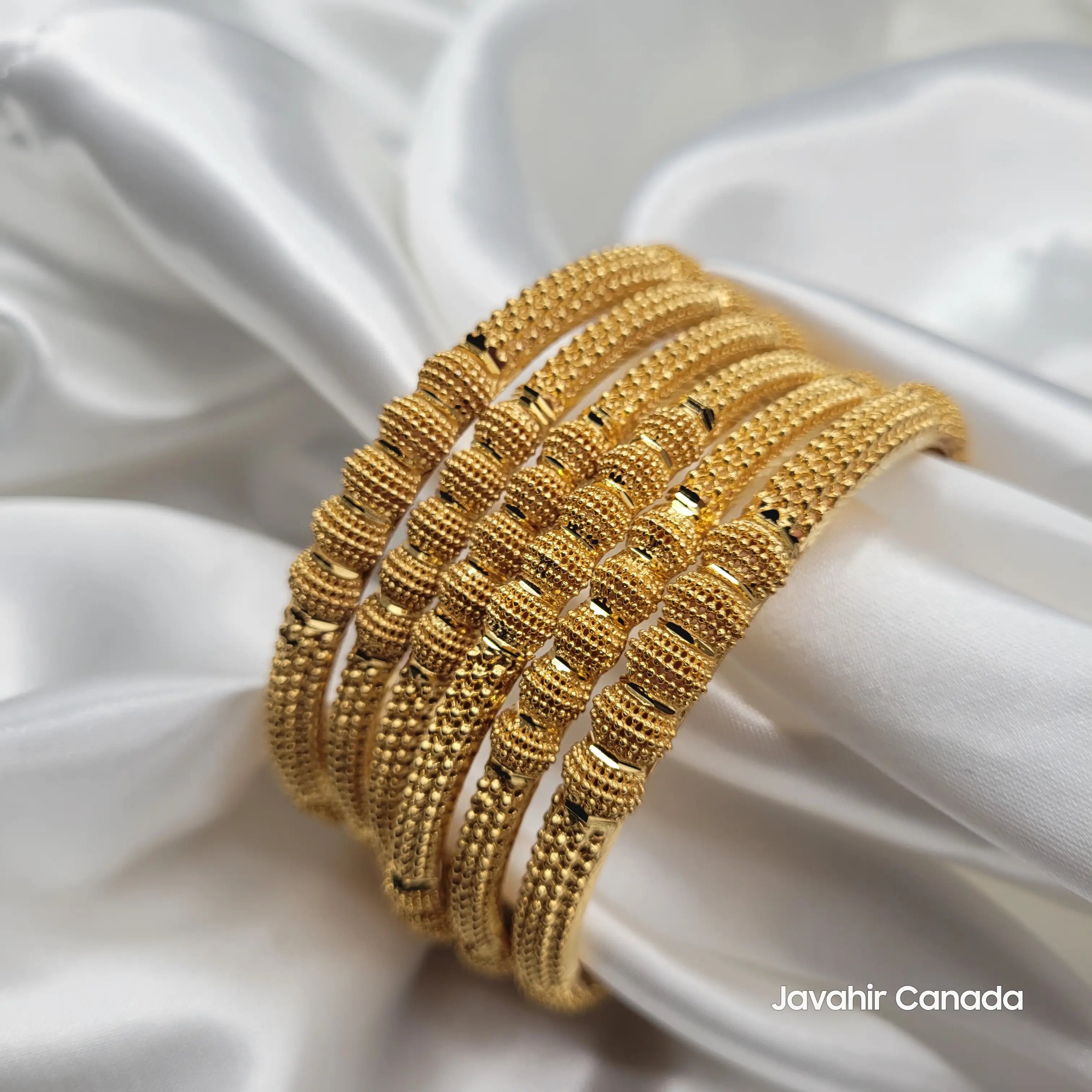 Angled view of JV3037 beaded bangles on white satin