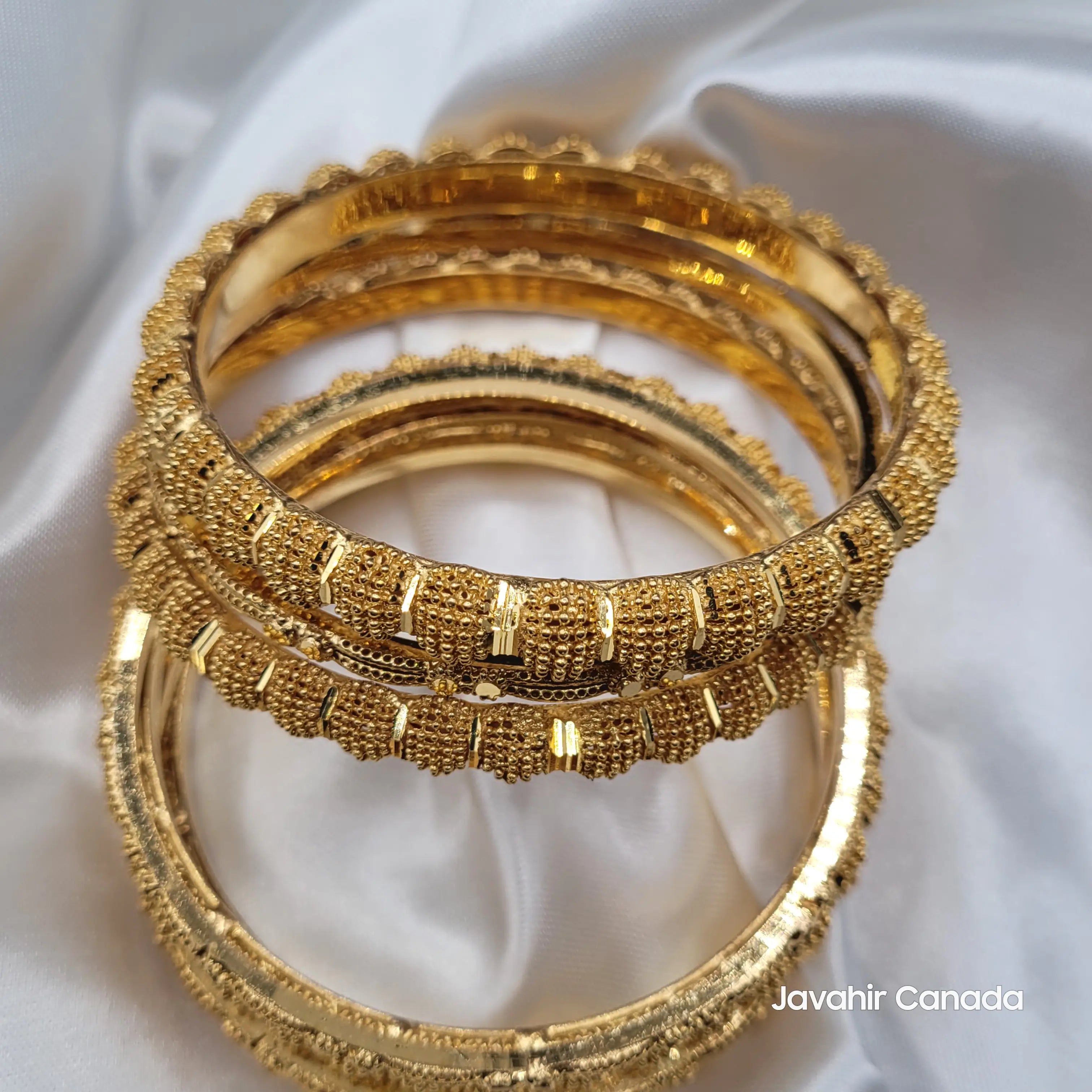 JV3040 7-piece gold bangle set with thick and thin beaded textures on white satin