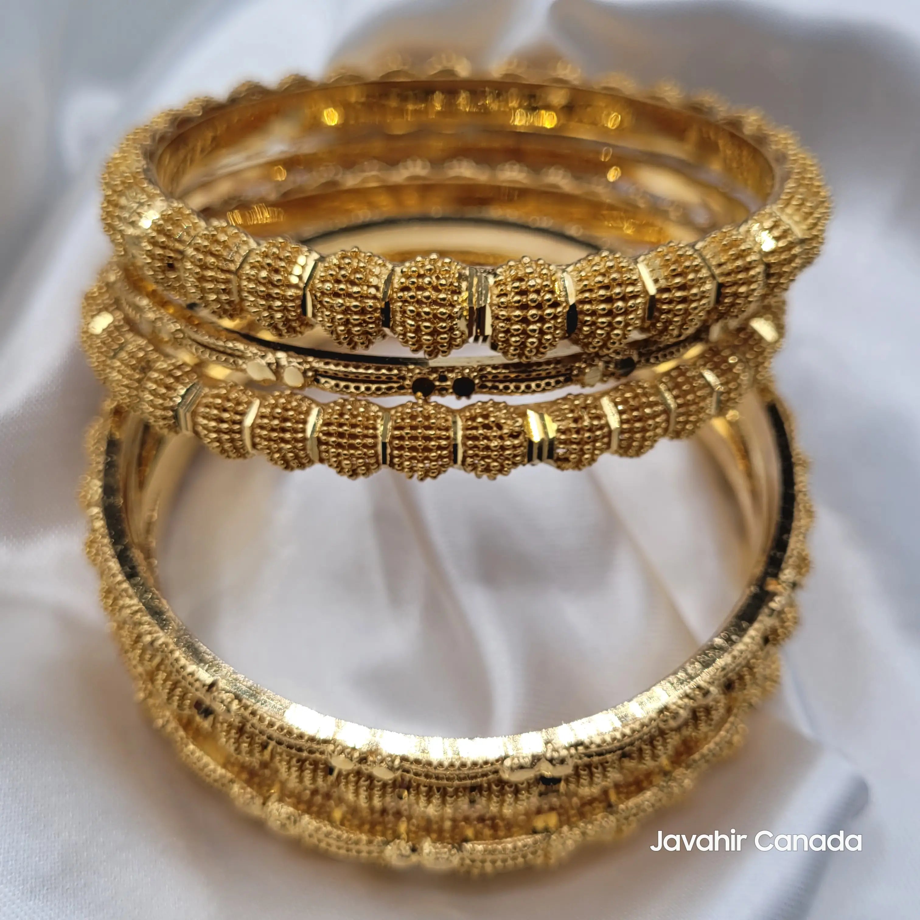 Side view of JV3040 gold bangles showing 4 thick and 3 thin beaded designs