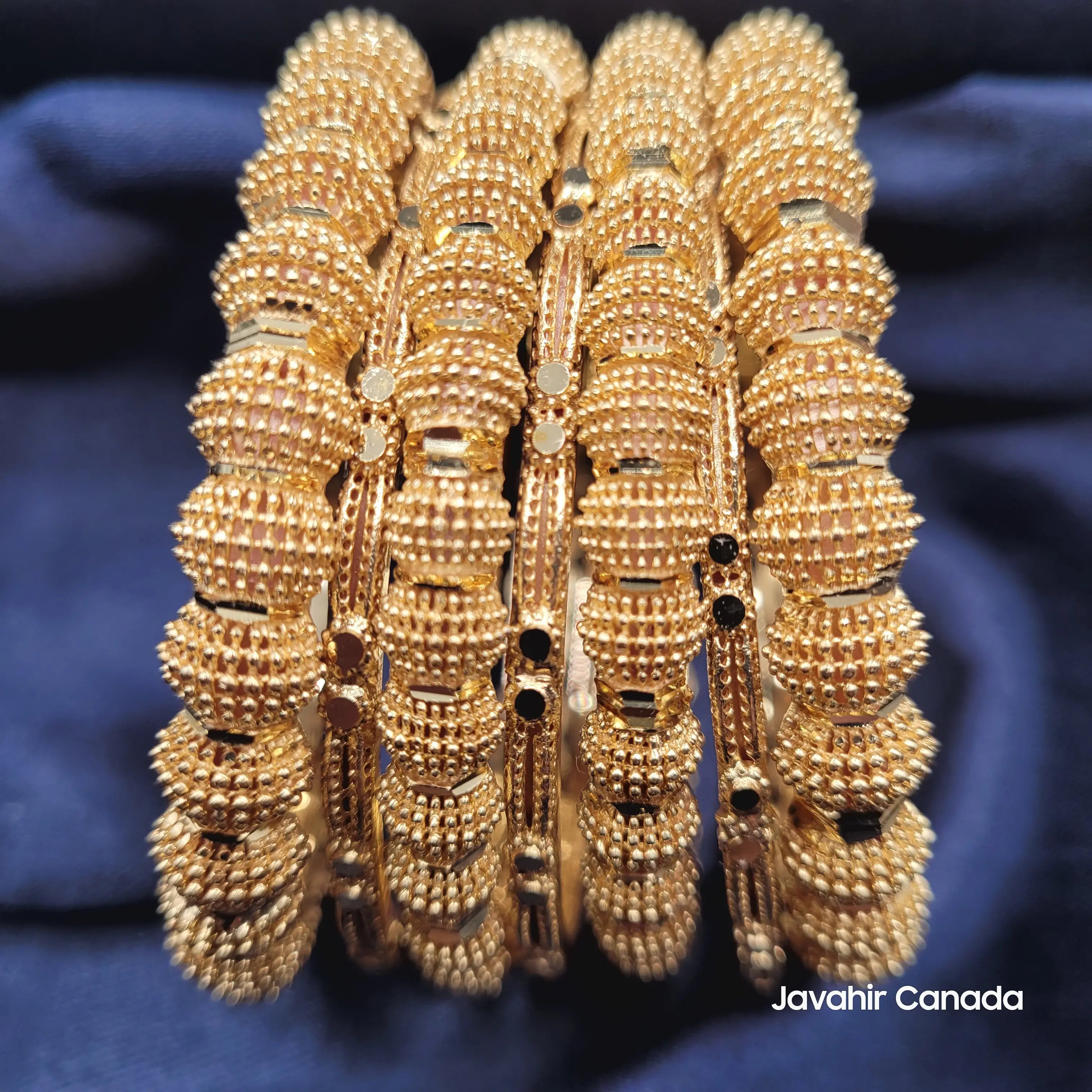JV3040 bangles set on navy fabric showing shine and detailed gold texture