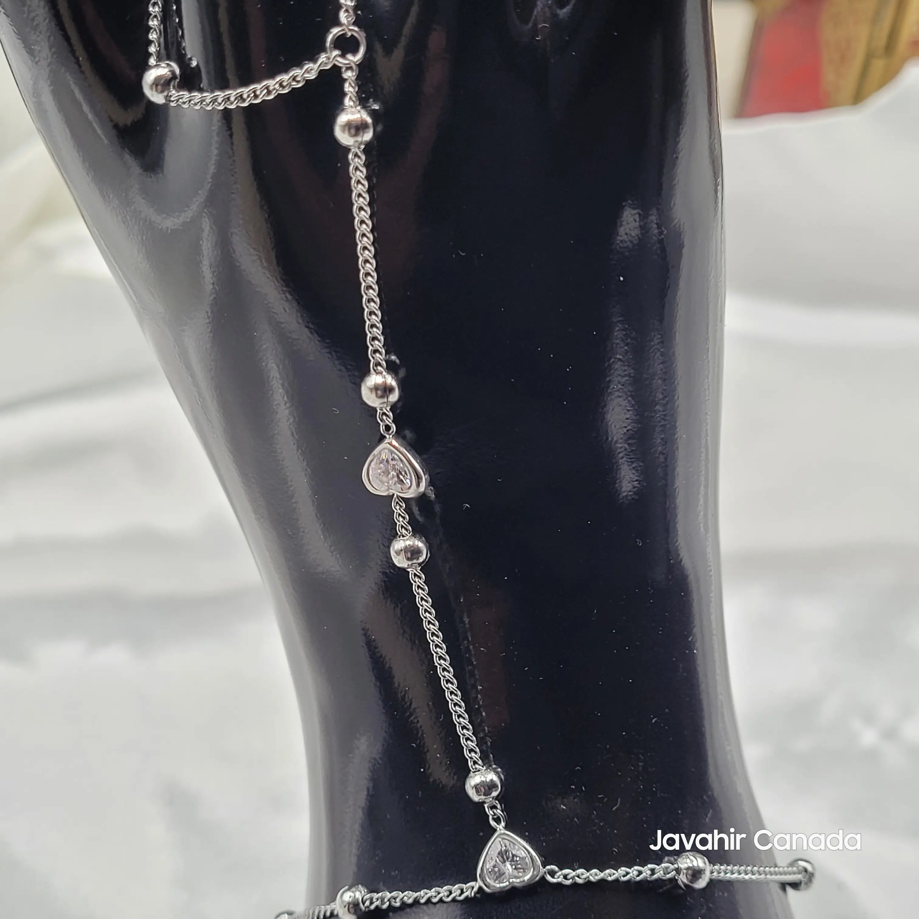 Close-up of center heart CZ charm on silver chain of JV4022 hand bracelet